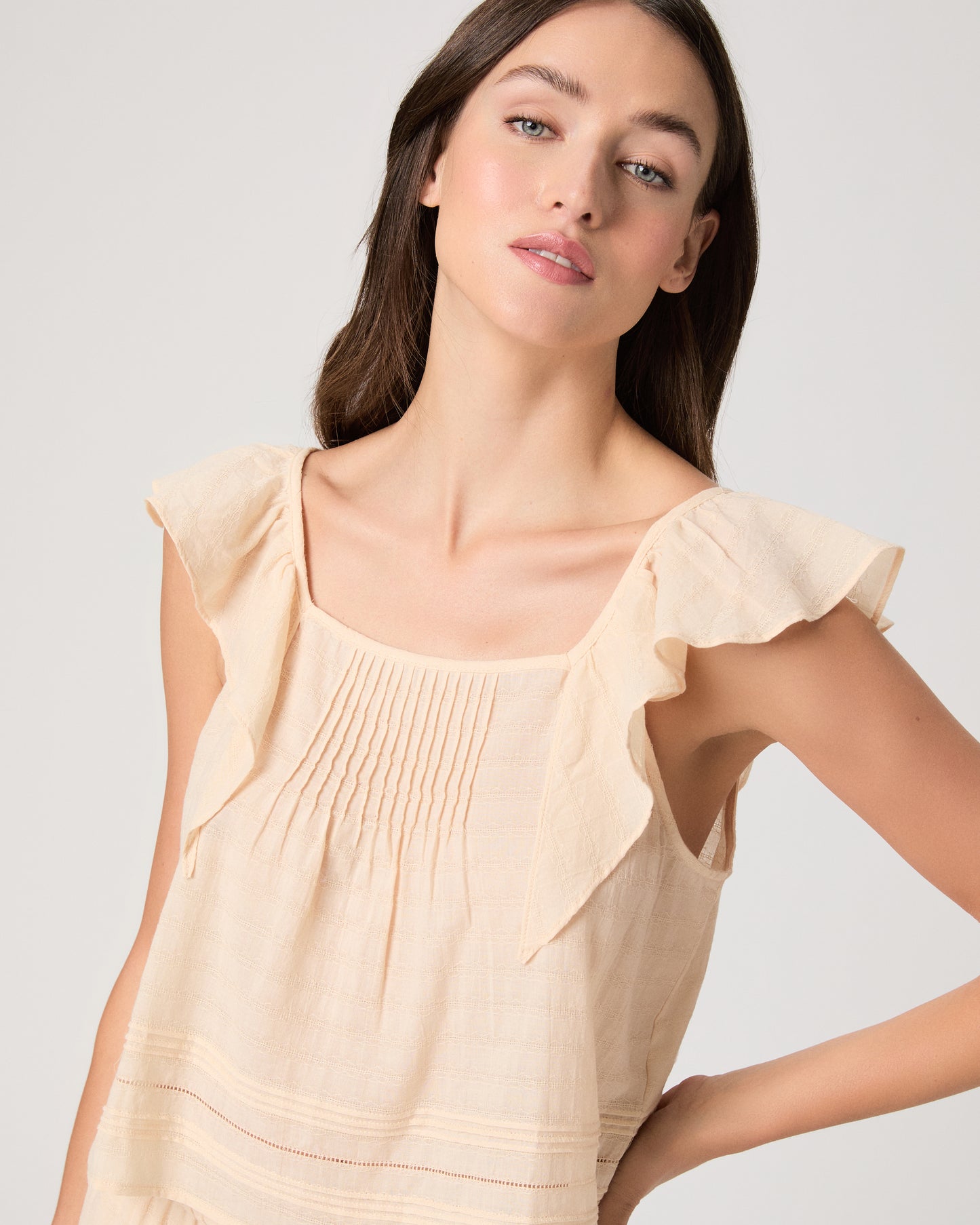 Model wearing a light peach midi skirt paired with a light peach top and brown sandals