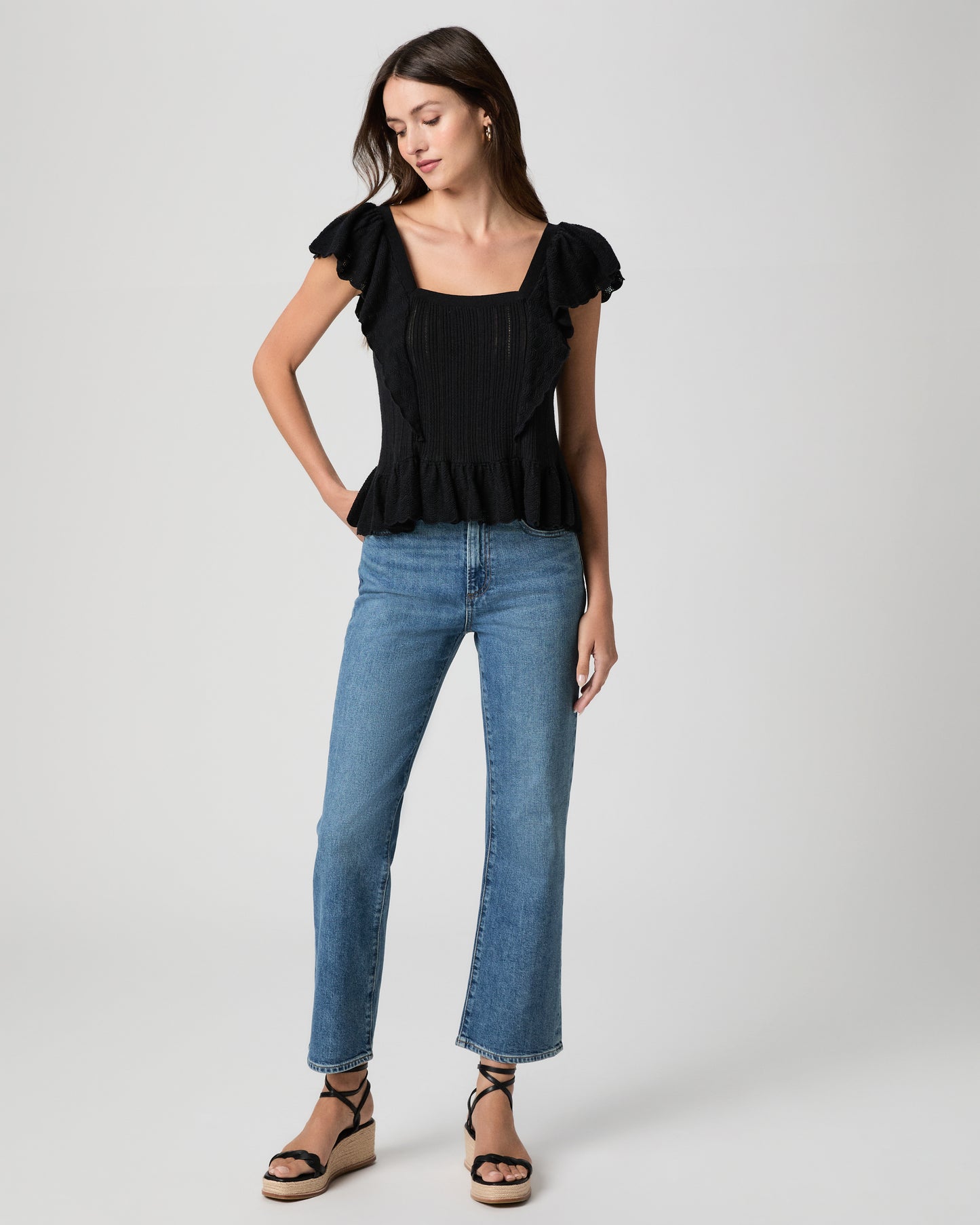 Women wearing blue jean with a black top and black wedges.