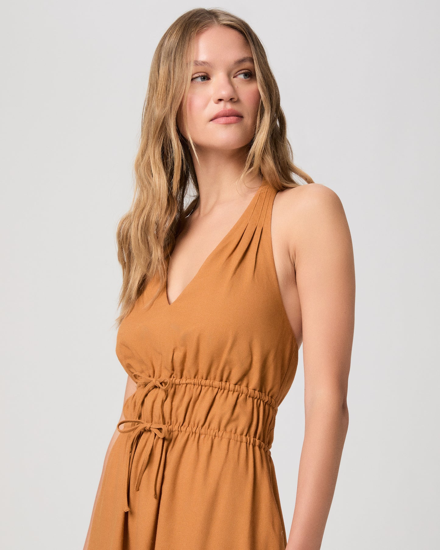 Woman wearing a mustard yellow dress on a white background