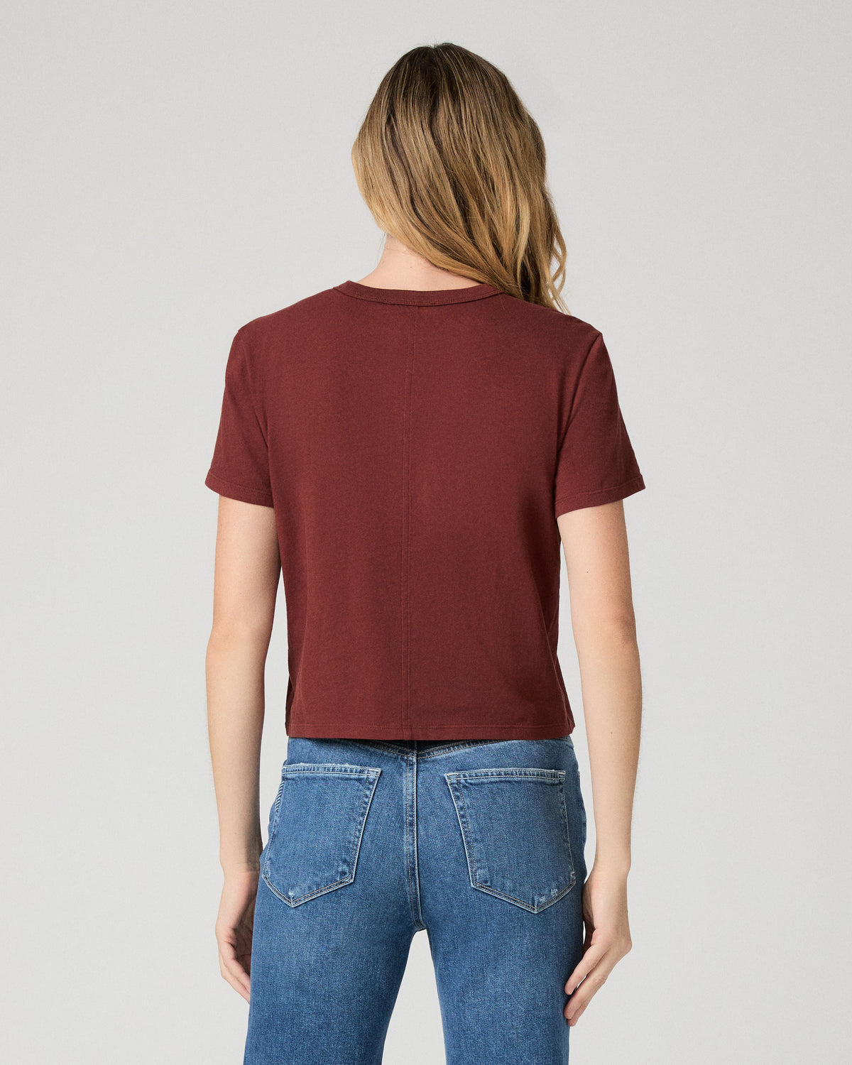 Women wearing red tee and blue jeans against a white background