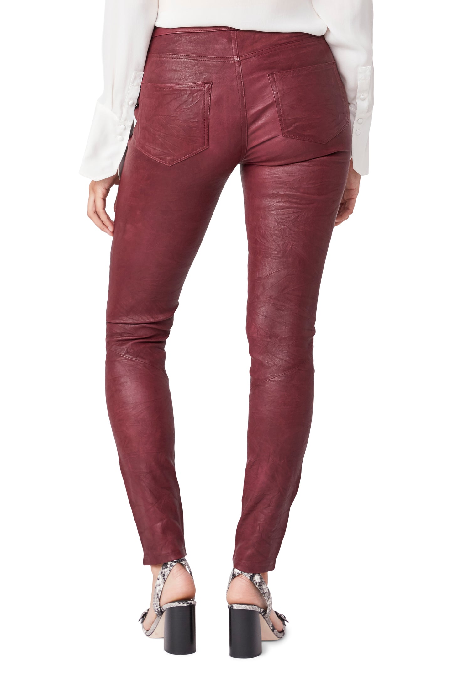 Maroon leather pants worn by a person on a white background