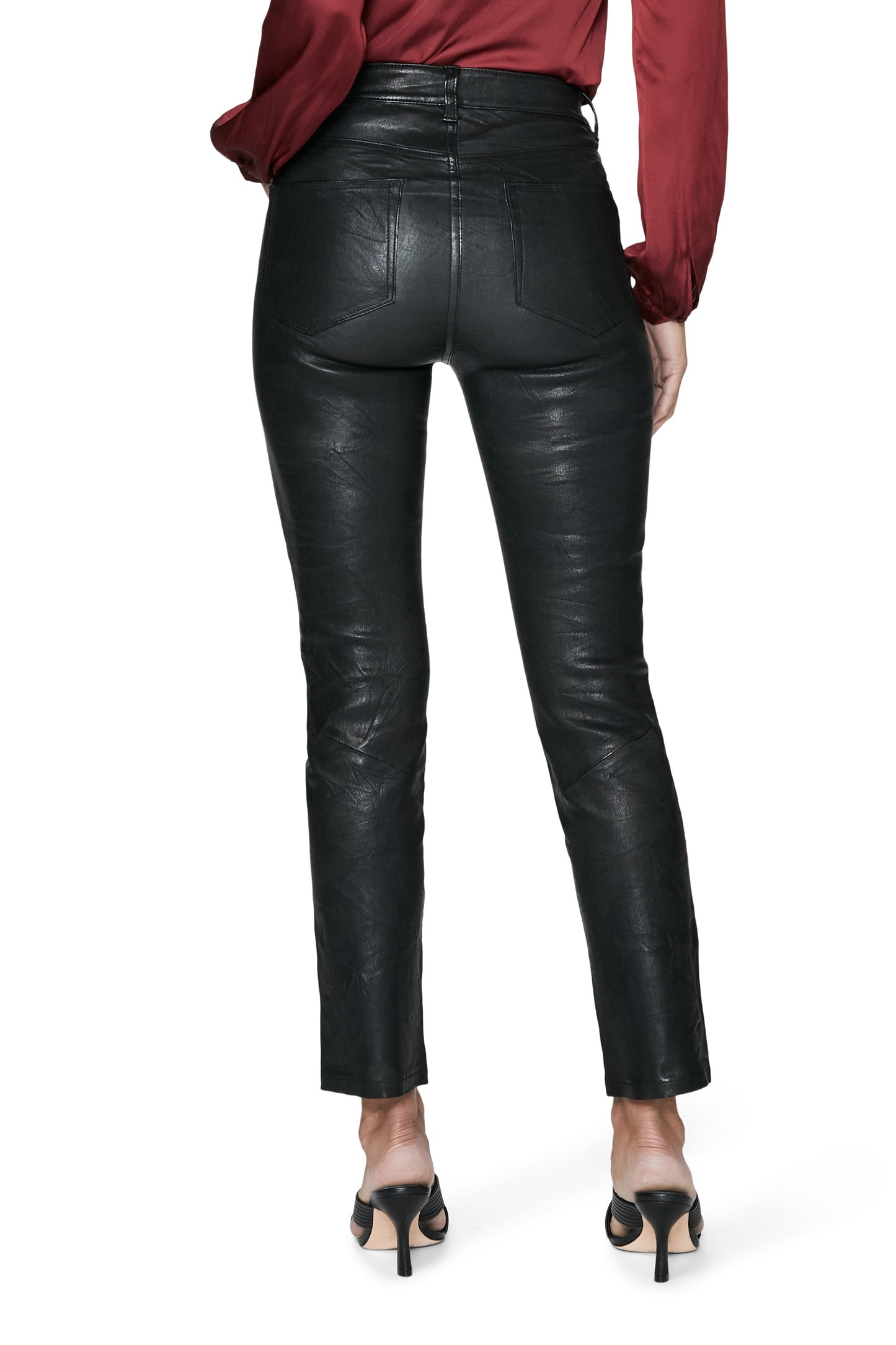 Black leather pants worn by a person on a white background