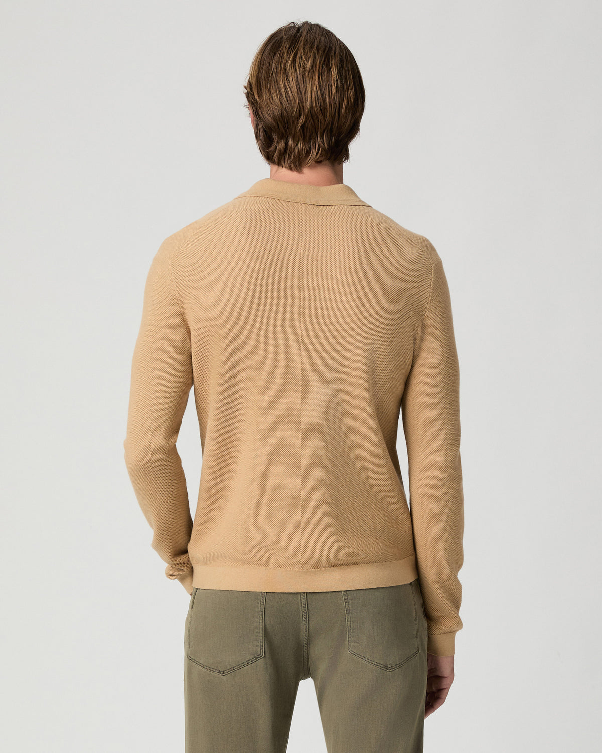 Back view of model wearing the Selwyn Sweater Polo in Brown Russet with olive pants