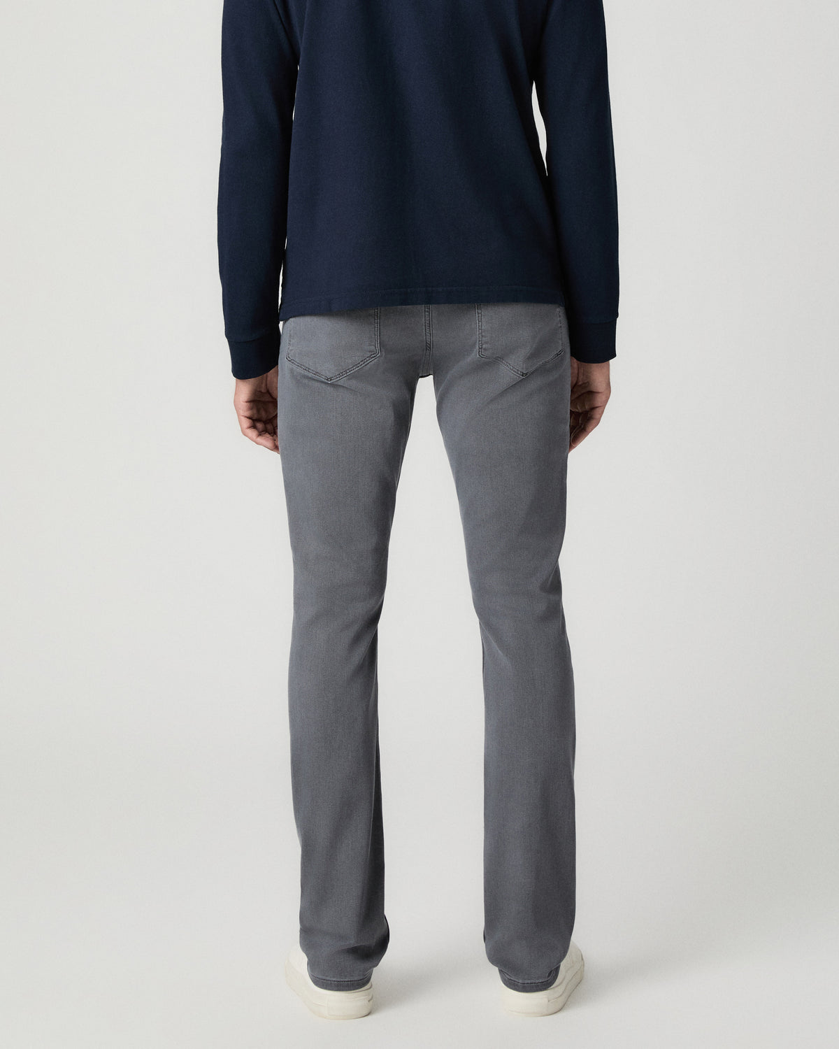 Back view from the waist down of the Lennox 32 Inch Slim Jean in Vintage Icy River, worn with white sneakers