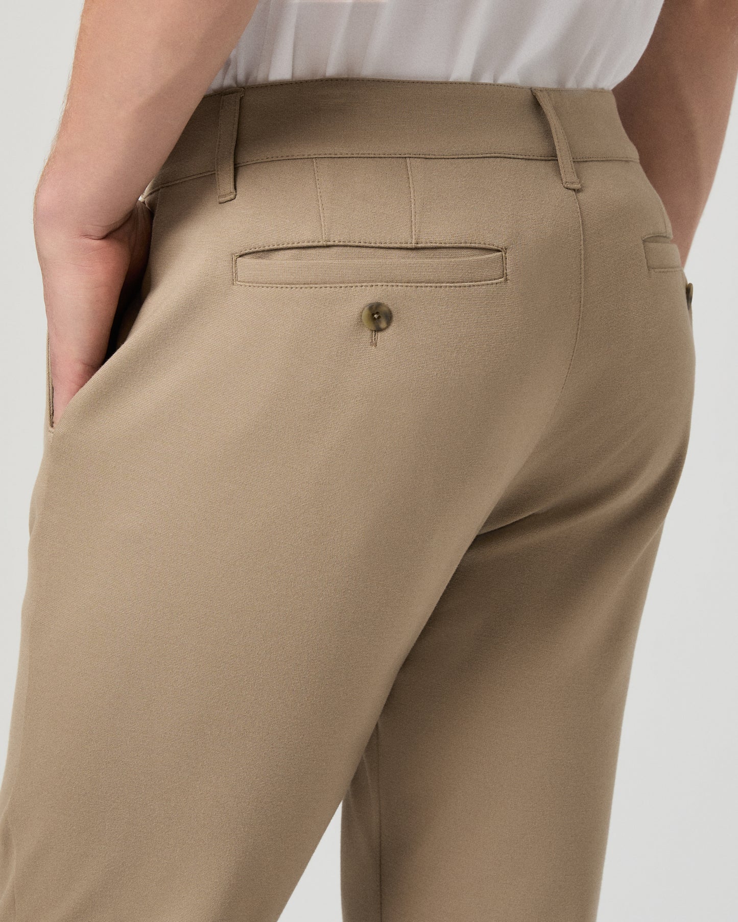 Man wearing a white tee and beige pants on a white background