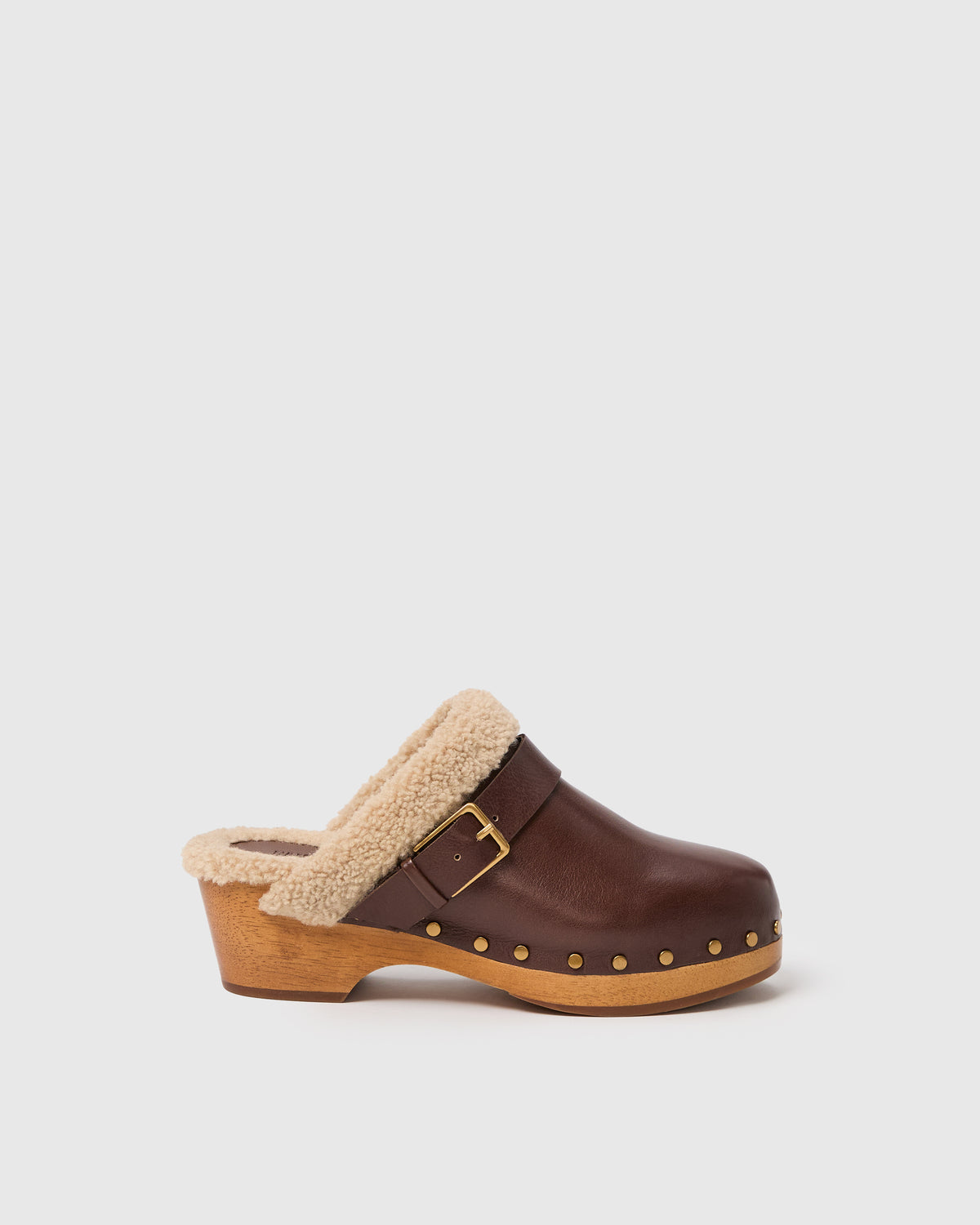 Brown clog shoe with shearling lining on a light gray background