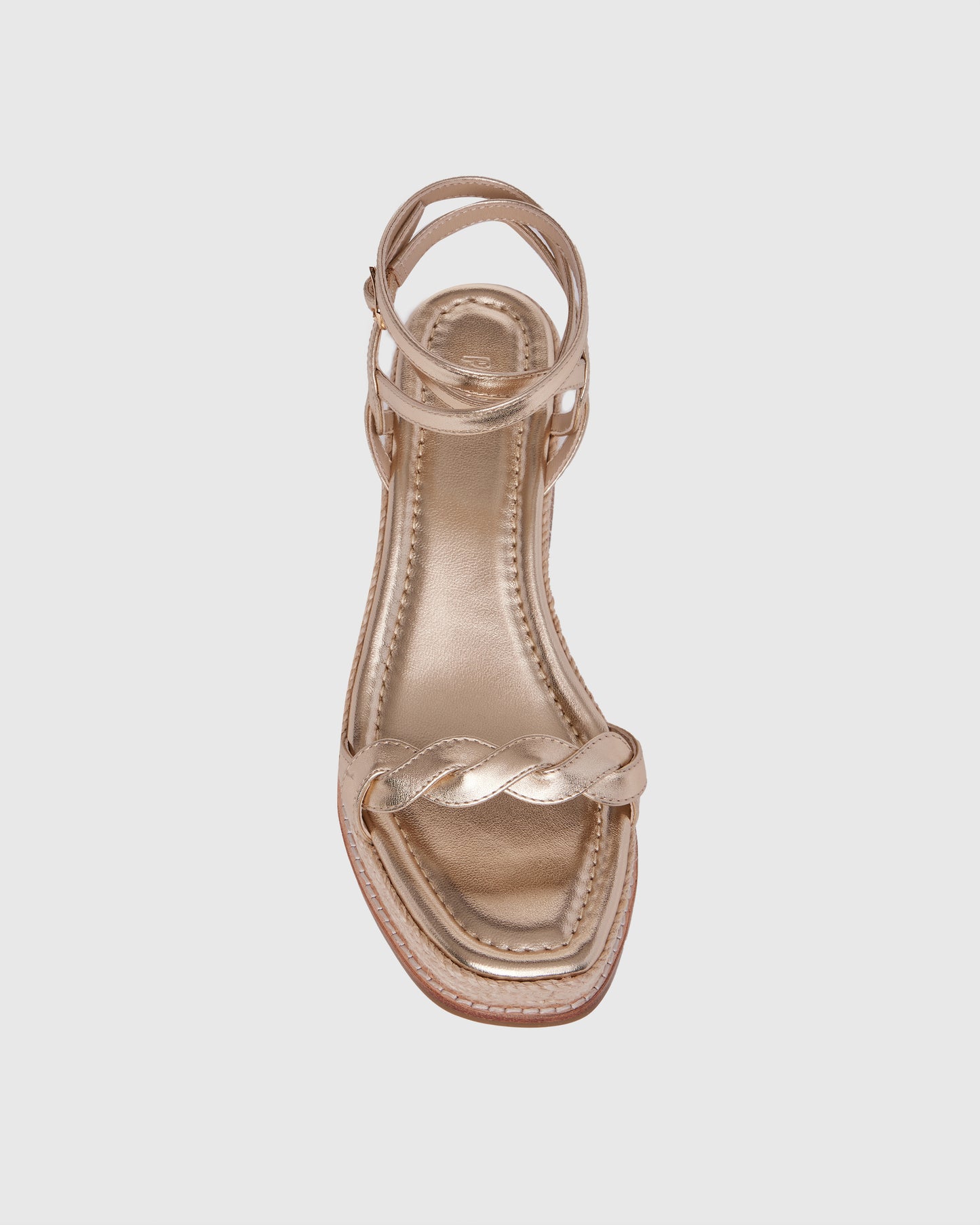Gold wedge sandal with espadrille sole on a light gray background