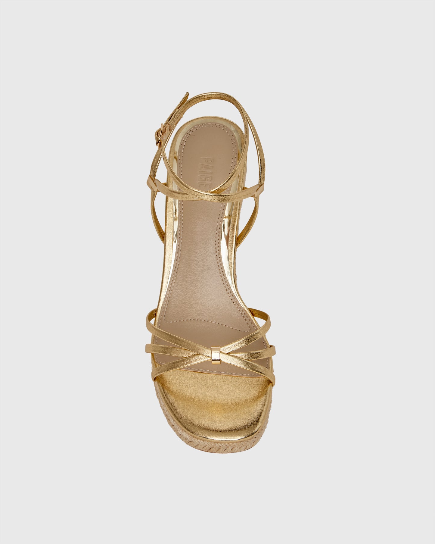 Gold wedge sandal with espadrille sole on a light gray background