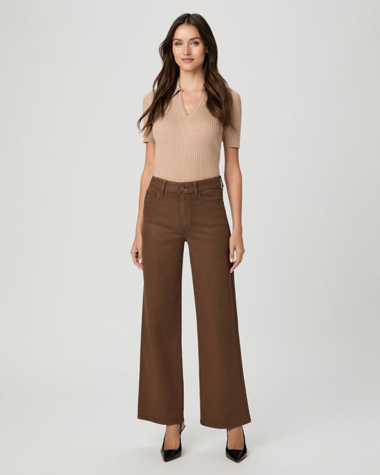 A woman modeling a beige ribbed short-sleeve top and brown wide-leg pants against a light gray studio background.