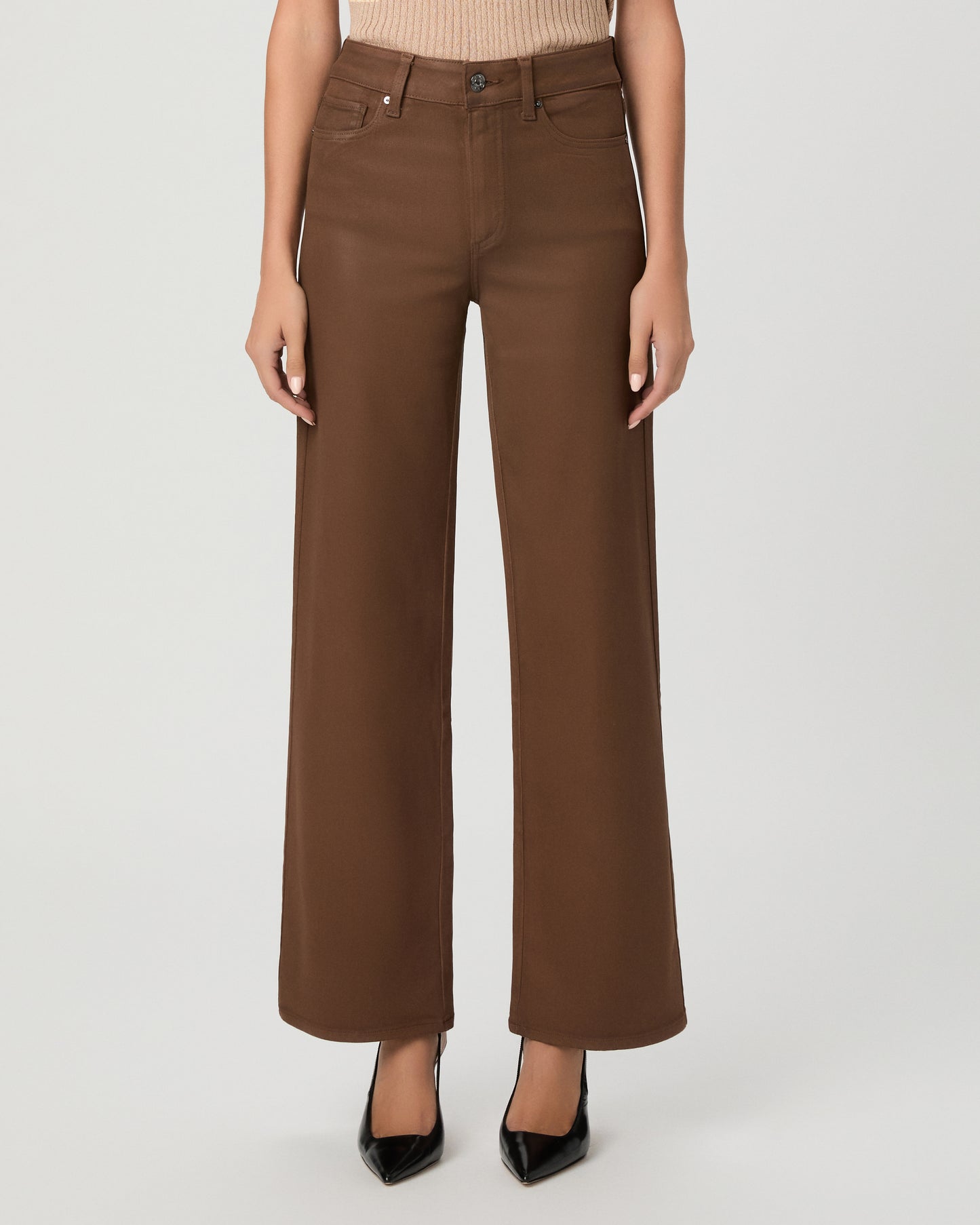 A woman modeling a beige ribbed short-sleeve top and brown wide-leg pants against a light gray studio background.
