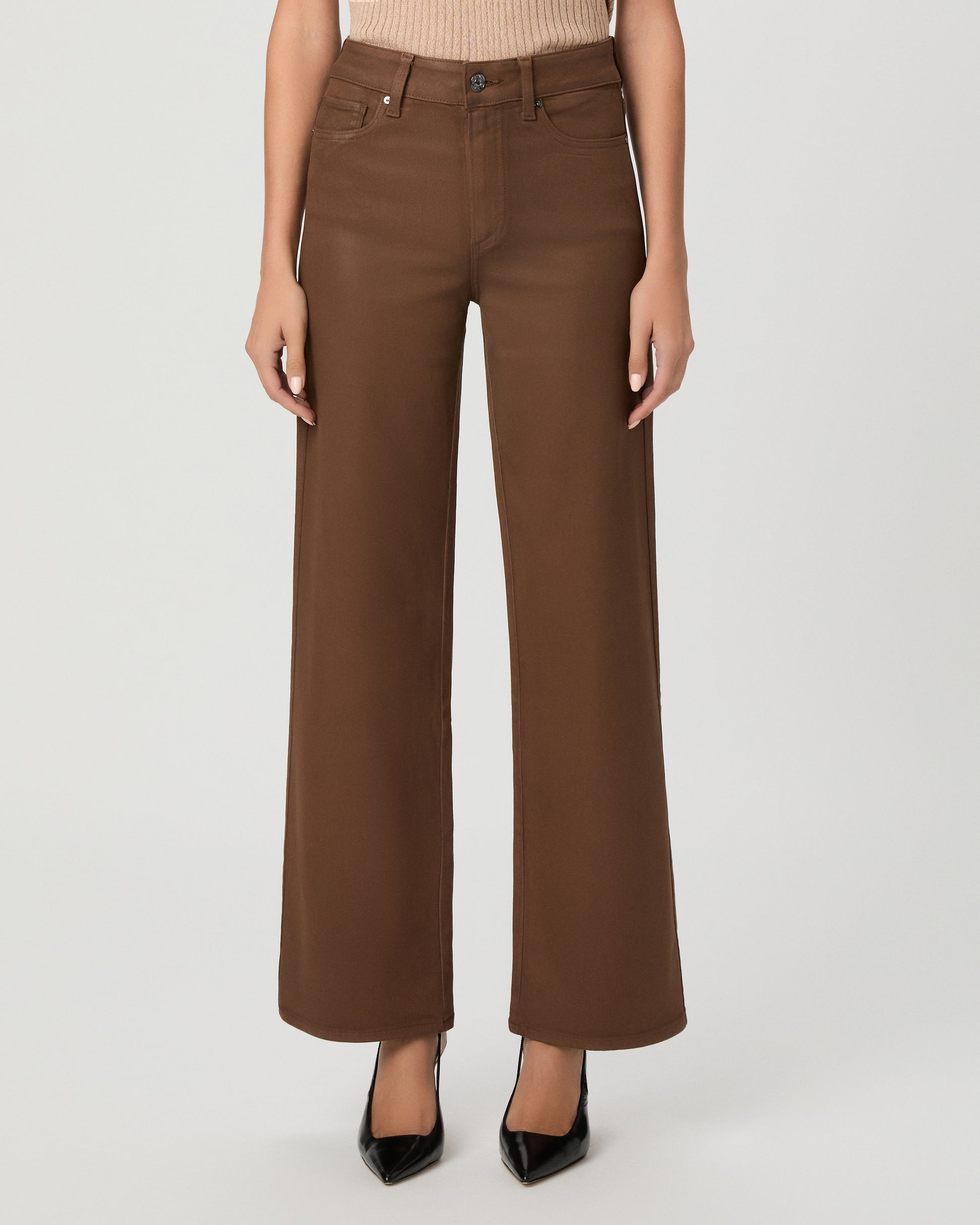 A woman modeling a beige ribbed short-sleeve top and brown wide-leg pants against a light gray studio background.