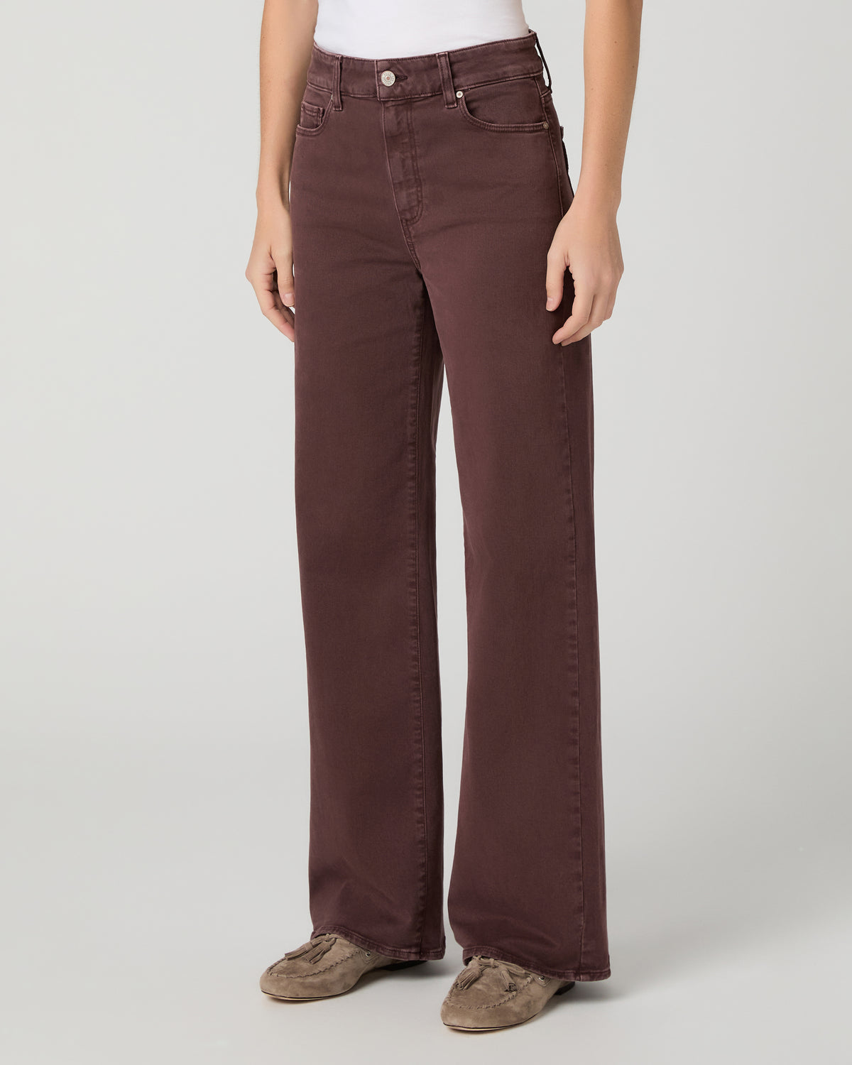 Women wearing a white top paired with burgundy jean and brown flats against a white background