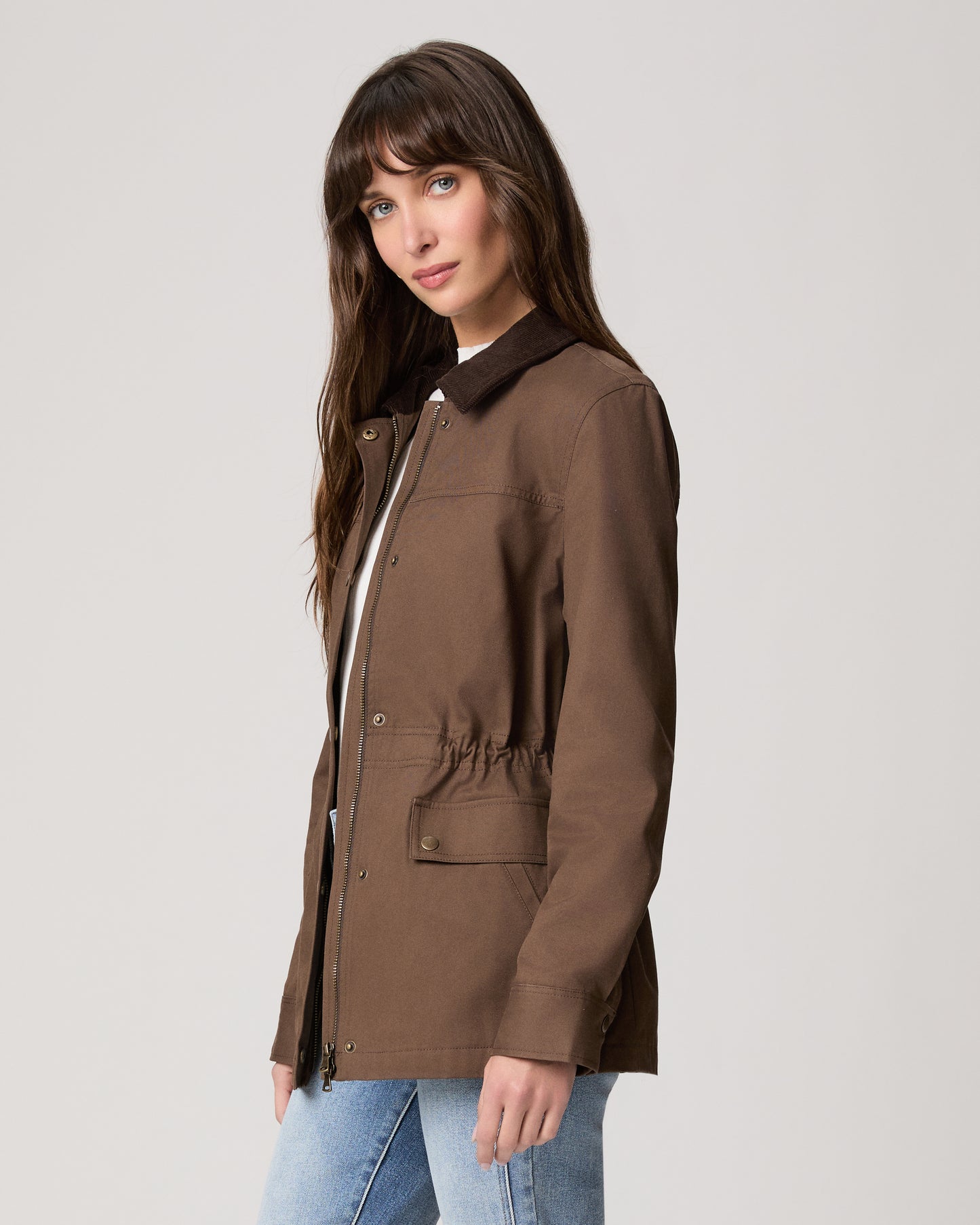 Woman wearing a brown jacket on a plain background