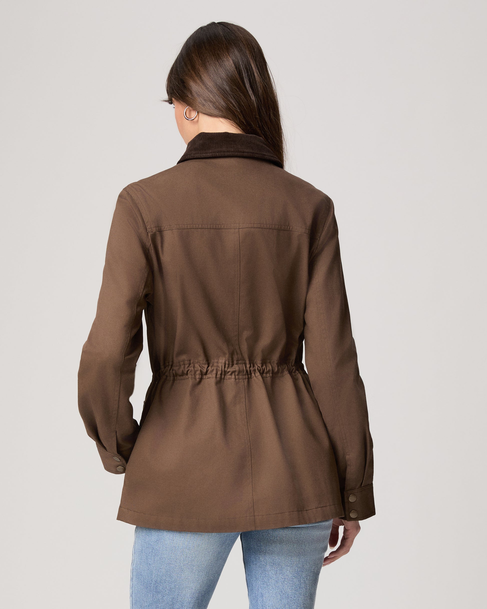 Woman wearing a brown jacket on a plain background