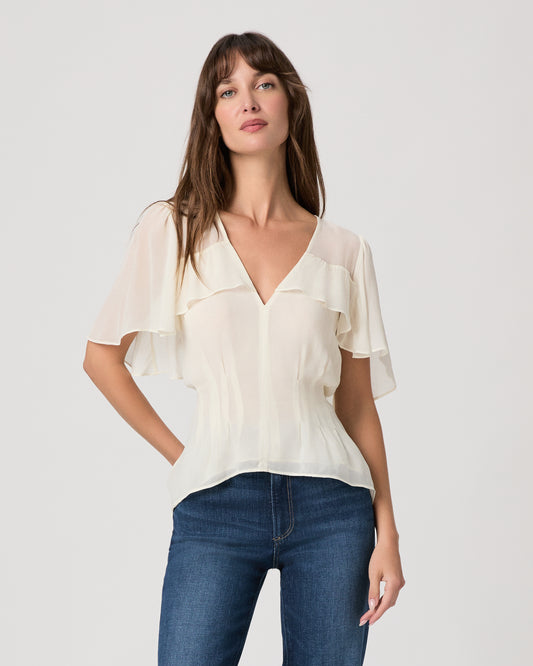Women wearing a white top paired with dark wash jeans