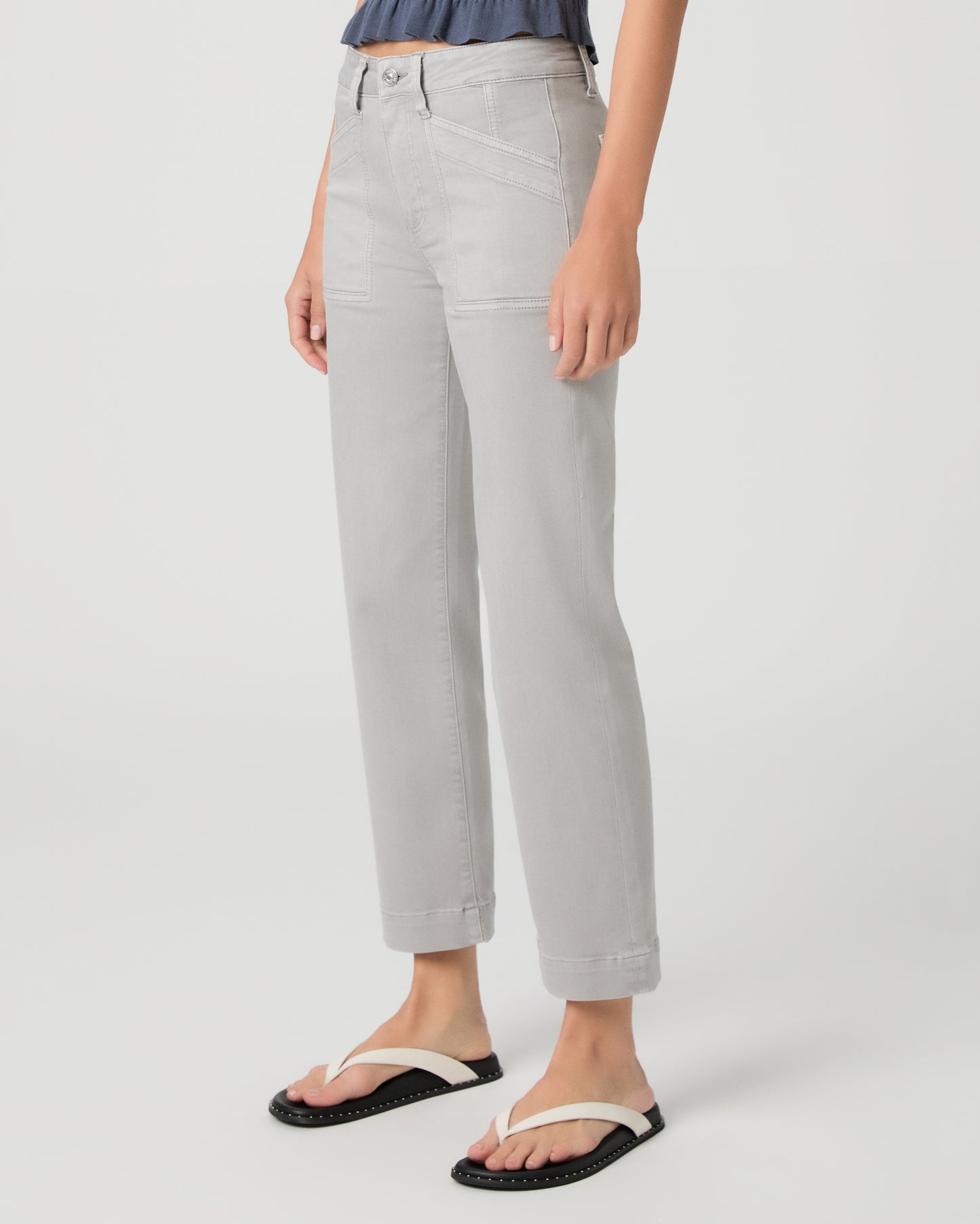 Person wearing light gray pants on a white background