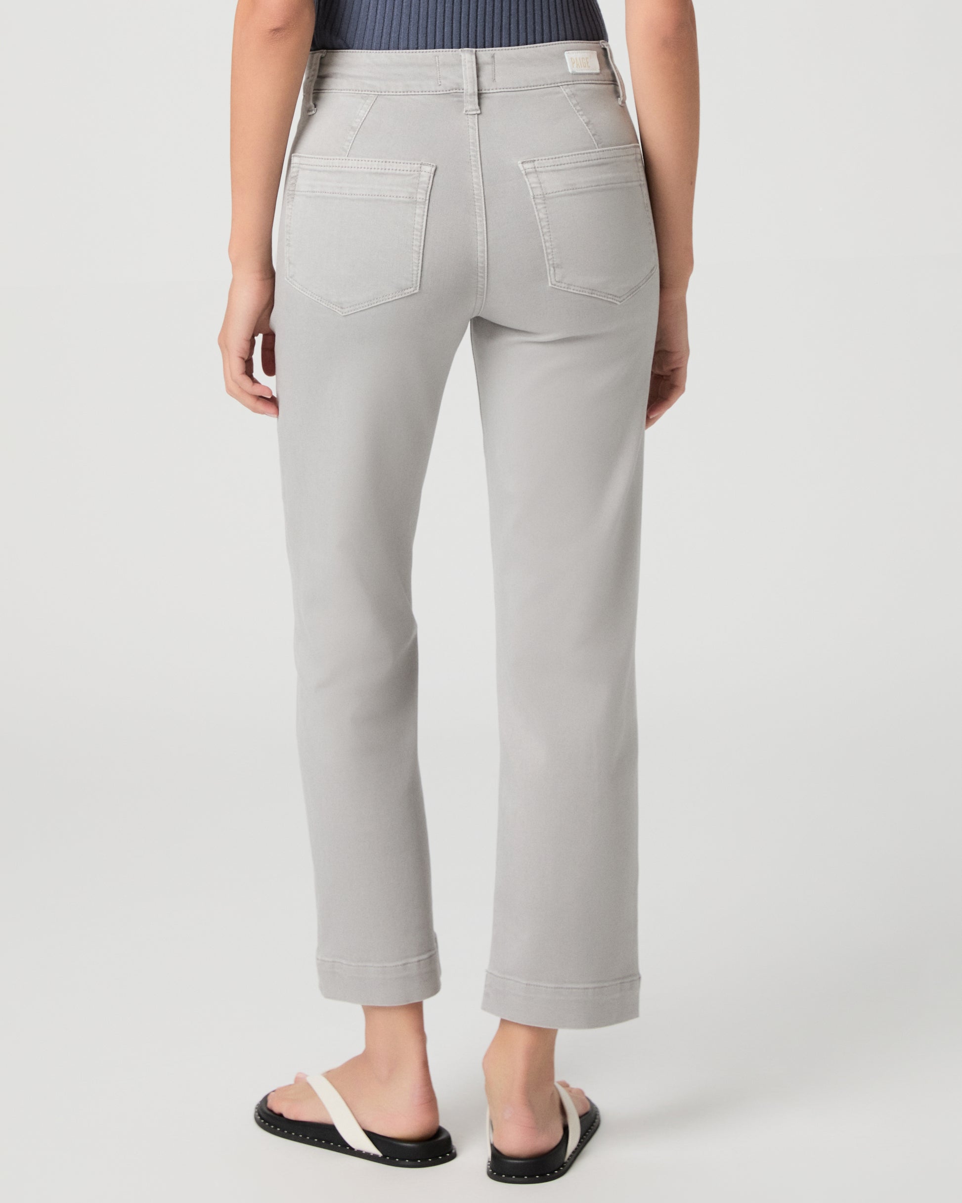 Person wearing light gray pants on a white background