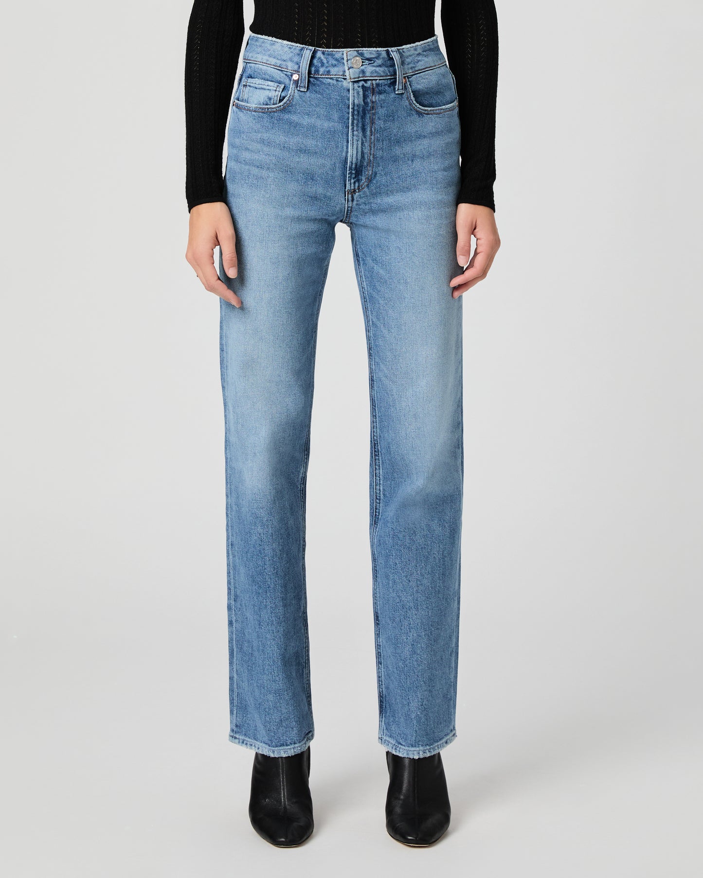 Person wearing light blue jeans on a white background