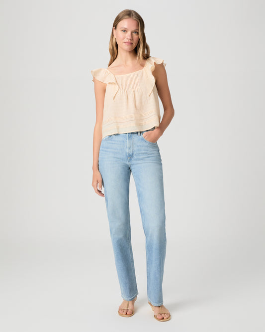 Women wearing a light yellow color top paired with light wash denim tank and gold sandals against a white background