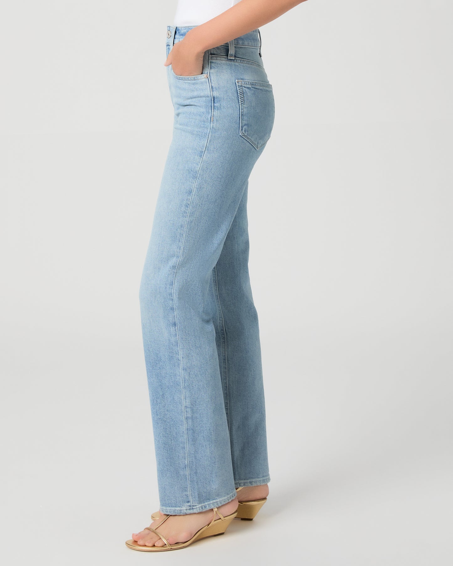 Women wearing a light yellow color top paired with light wash denim tank and gold sandals against a white background