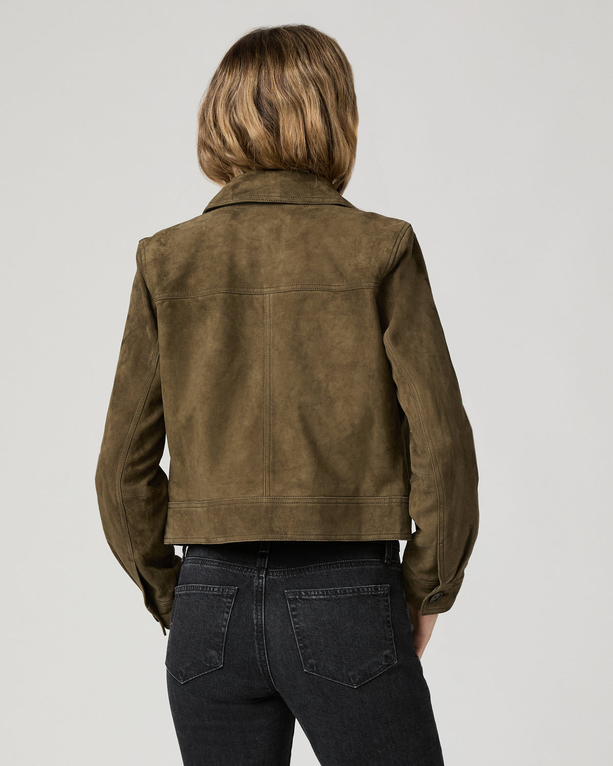 Back view of a woman wearing the rich olive suede Feyd Jacket, showing the back yoke detail.