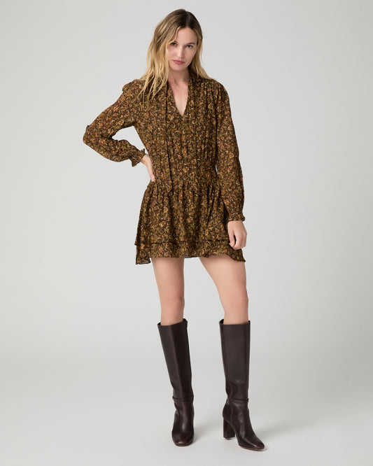 Women wearing flower printed brown dress paired with brown tall boots against a white background