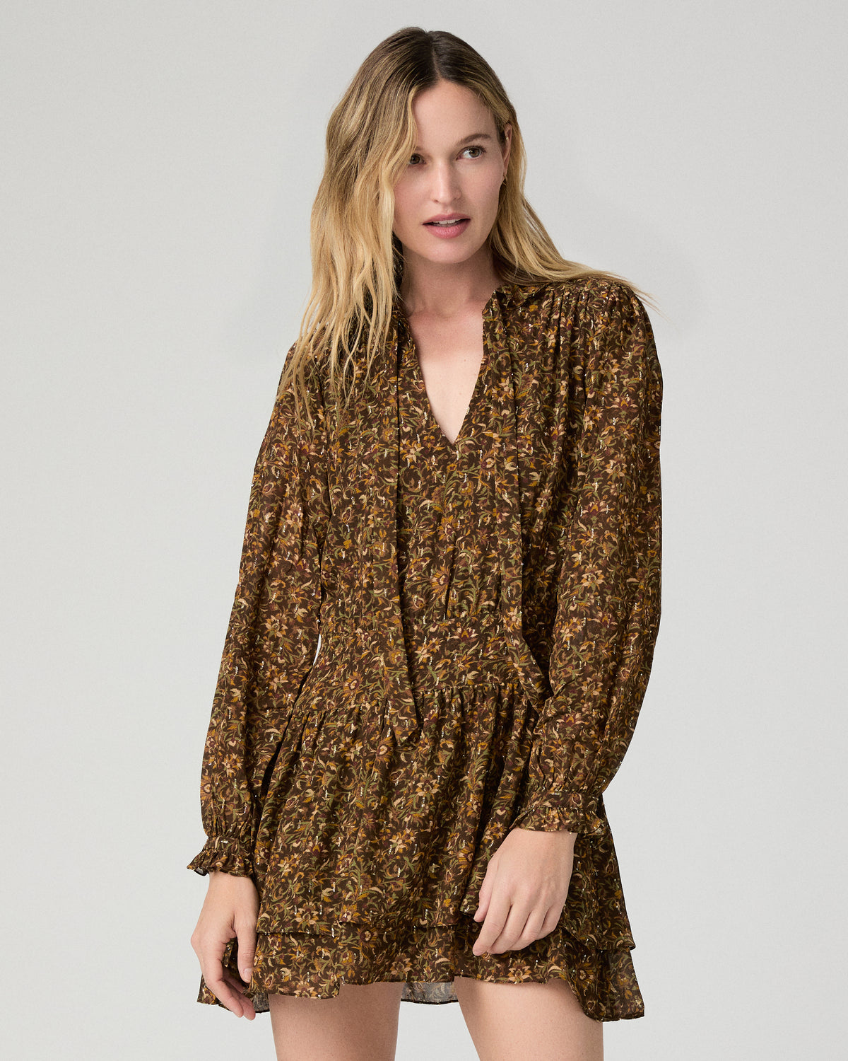 Women wearing flower printed brown dress against a white background