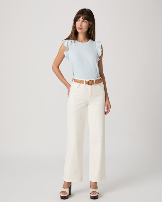 Woman wearing a light blue top paired with a white flare denim with a brown belt on a white background