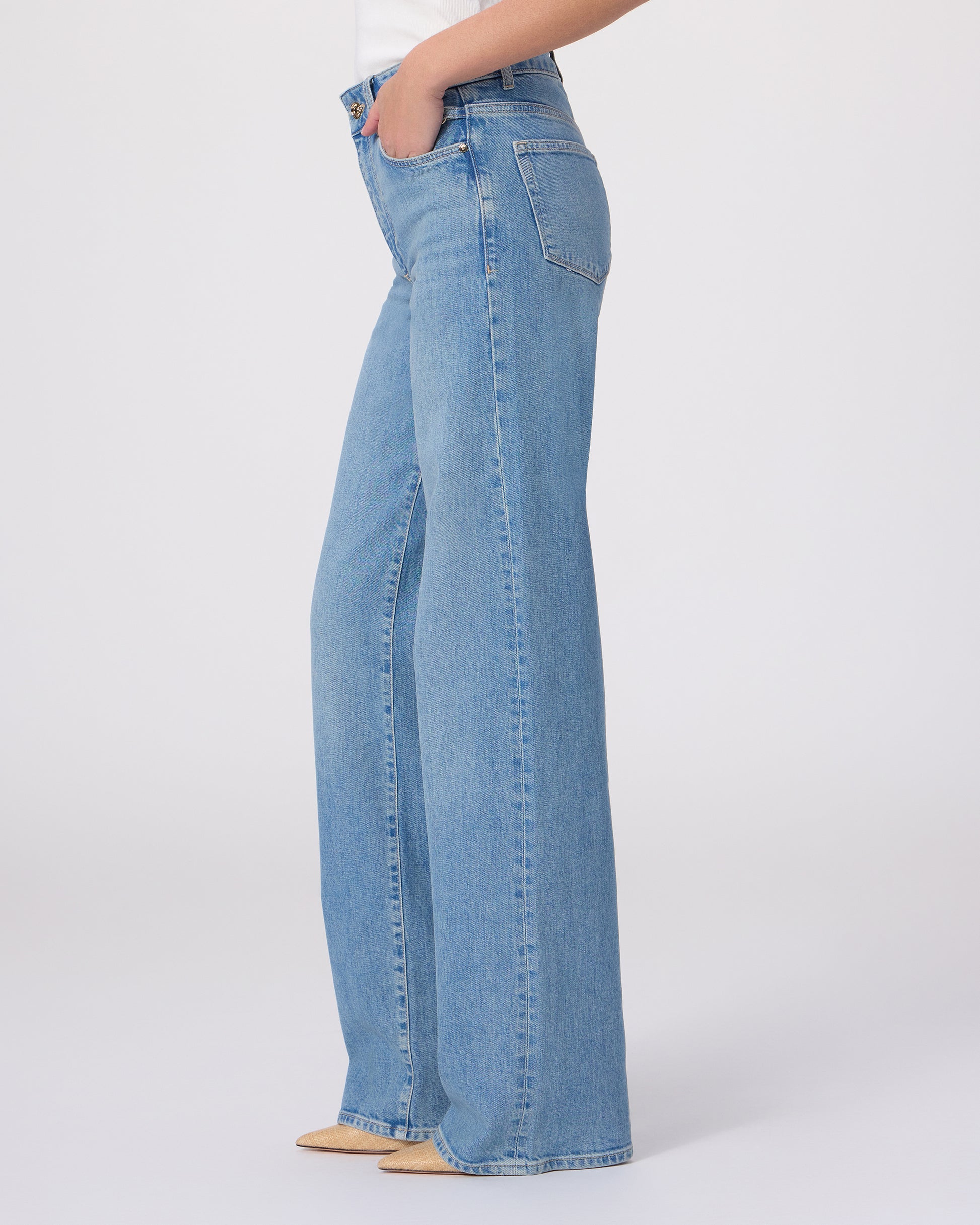 Woman wearing a white blouse and blue jeans on a white background