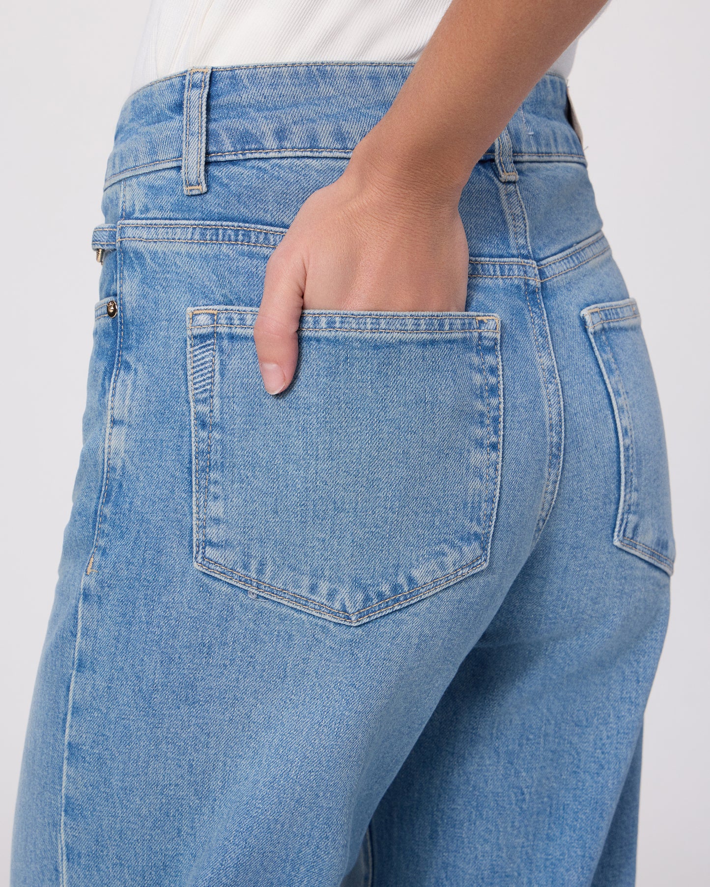 Woman wearing a white blouse and blue jeans on a white background