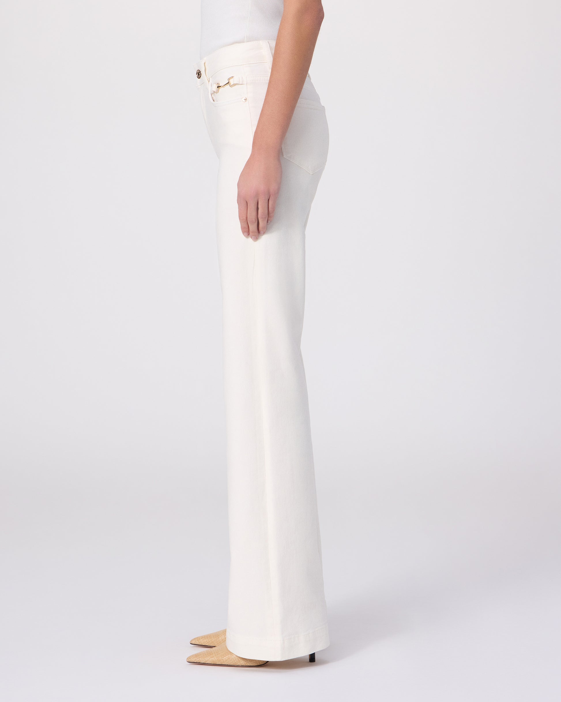 Woman wearing a white tee and white pants on a white background