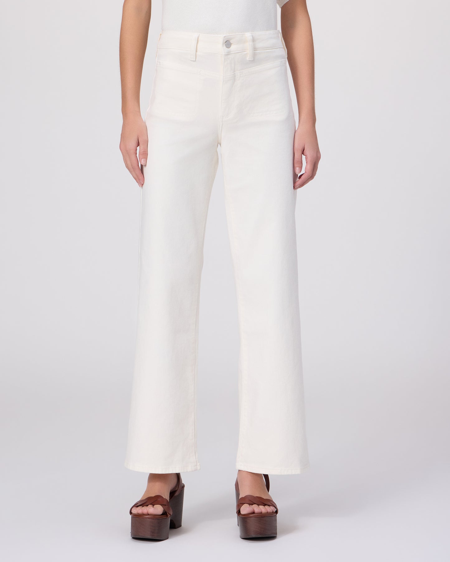 Woman wearing a white outfit with a brown belt on a white background