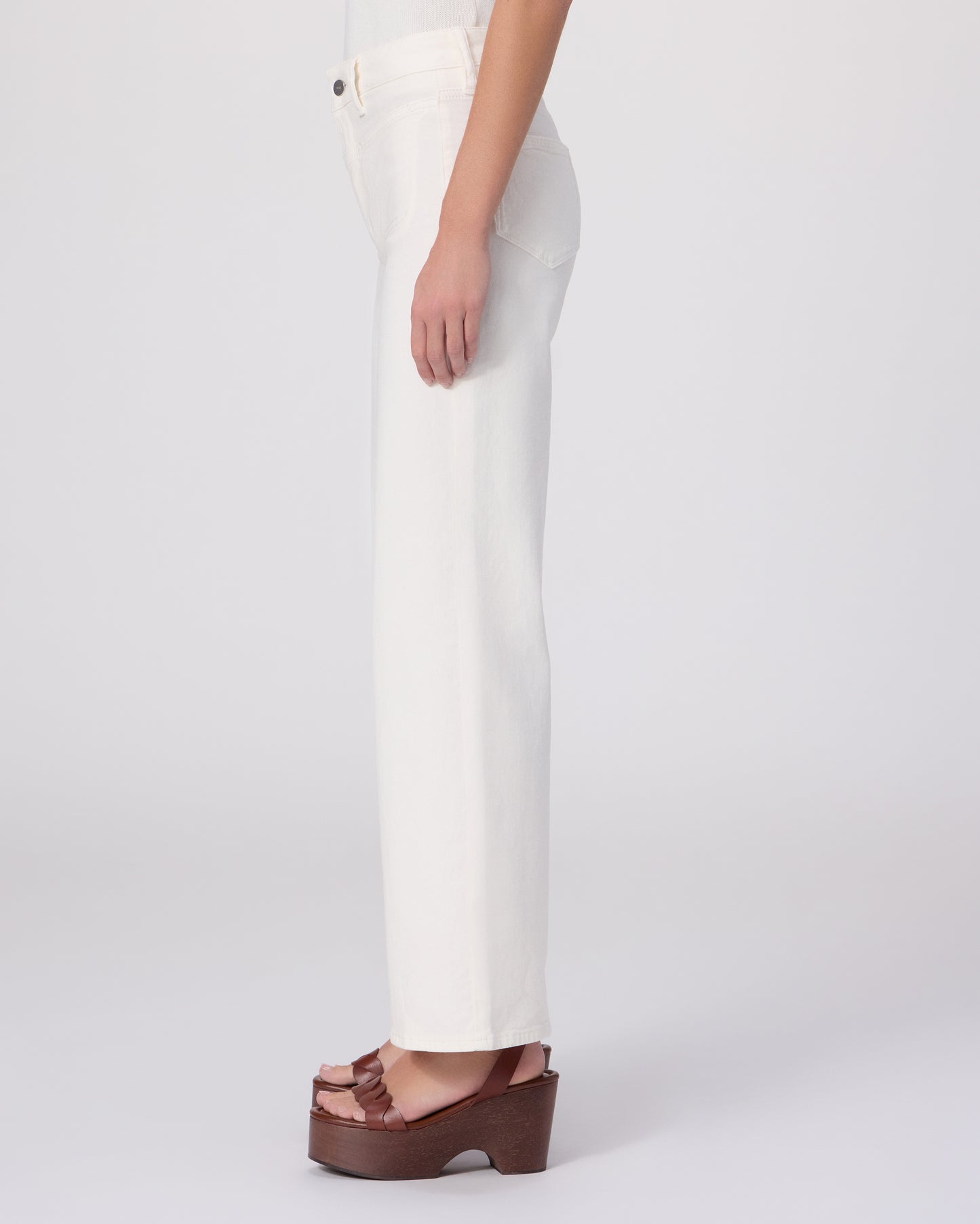 Woman wearing a white outfit with a brown belt on a white background