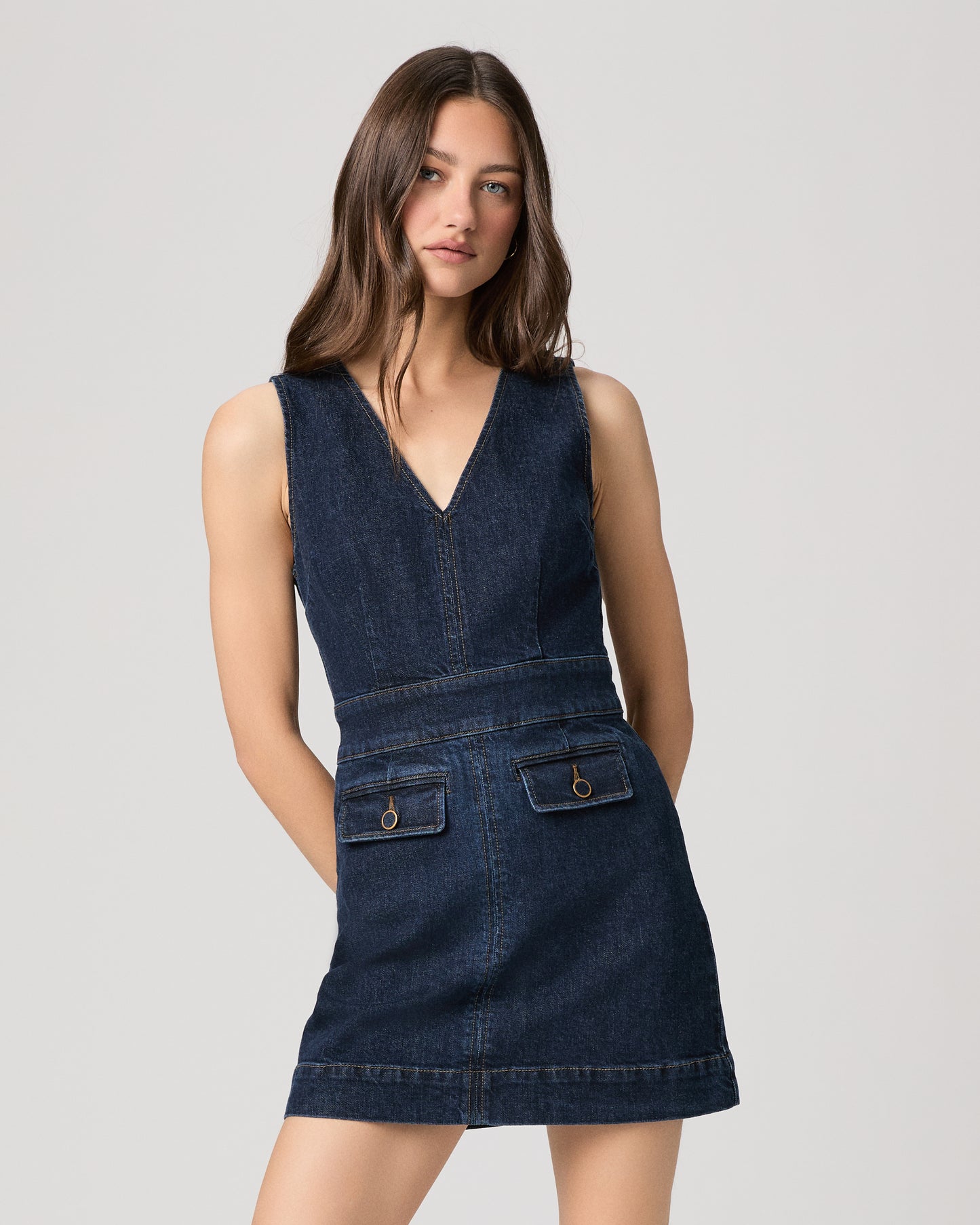 Woman wearing a mini denim dress on a white background
