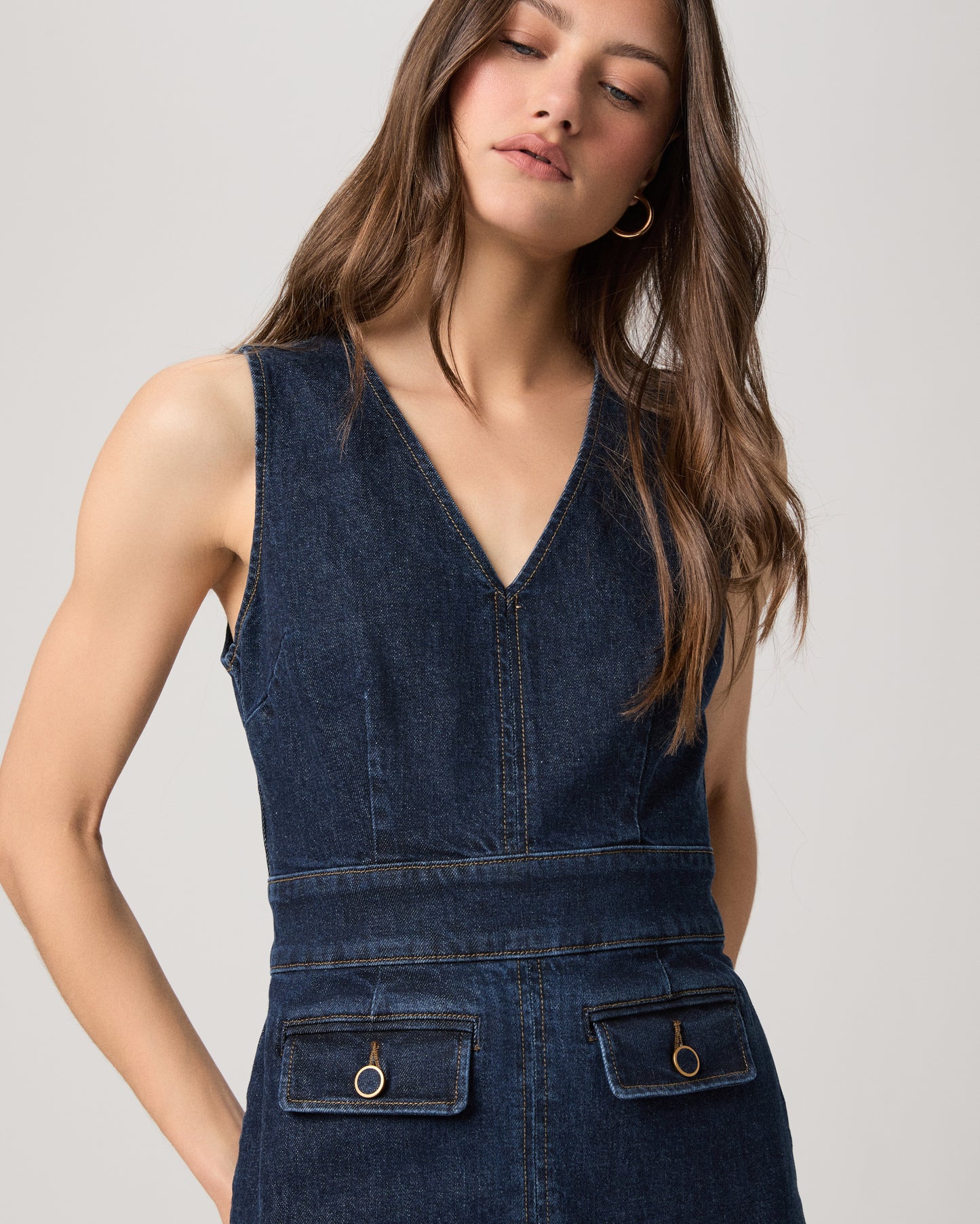 Woman wearing a mini denim dress on a white background
