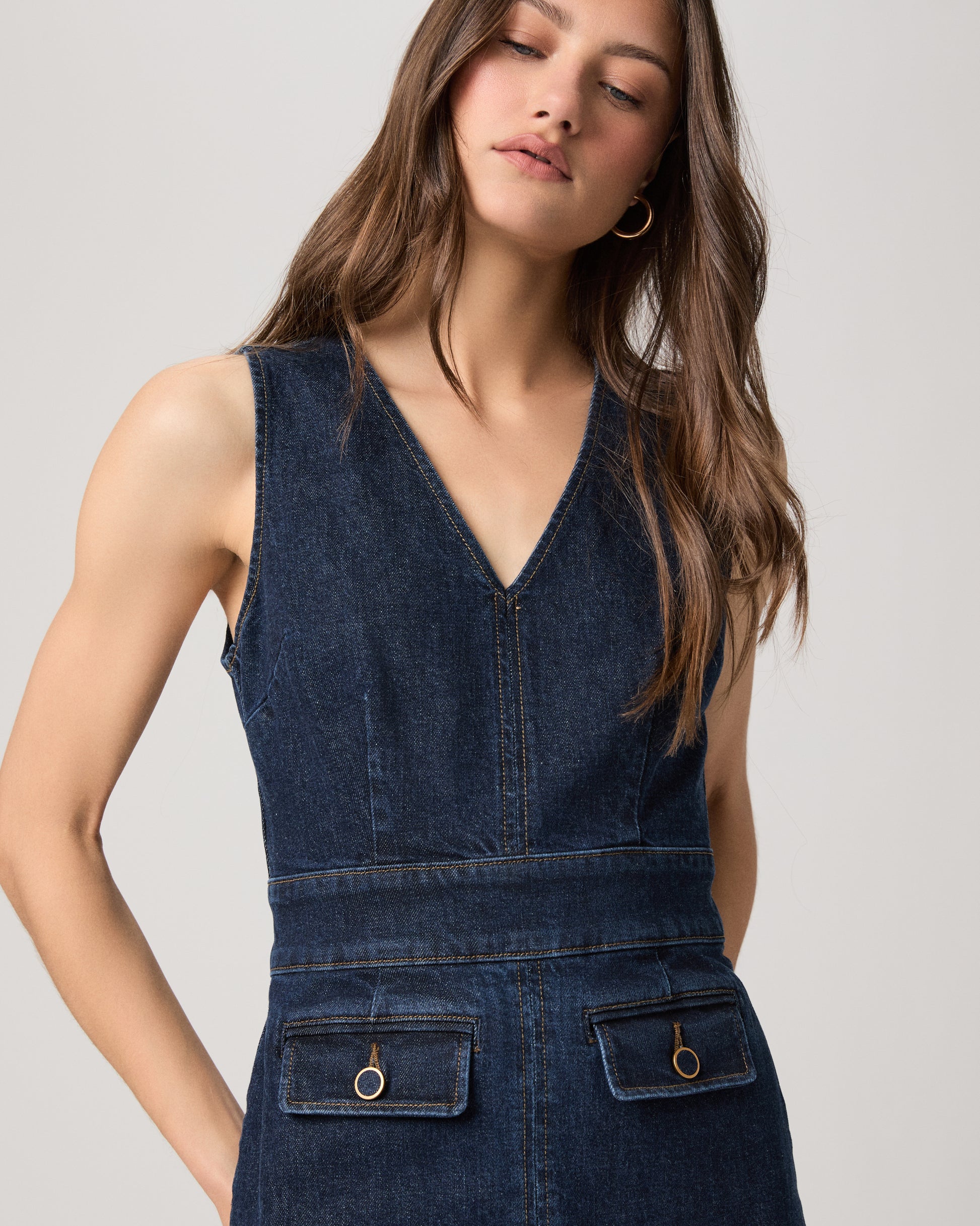 Woman wearing a mini denim dress on a white background
