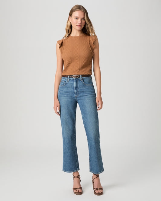 Women wearing a brown color top paired with medium wash denim and brown heels against a white background
