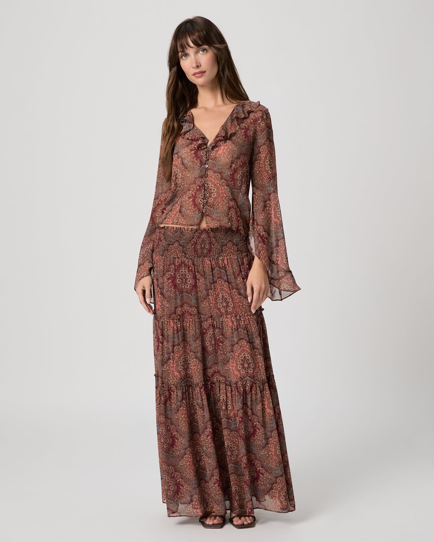 Model wearing a long sleeve flower print blouse paired with a matching flowy max skirt 