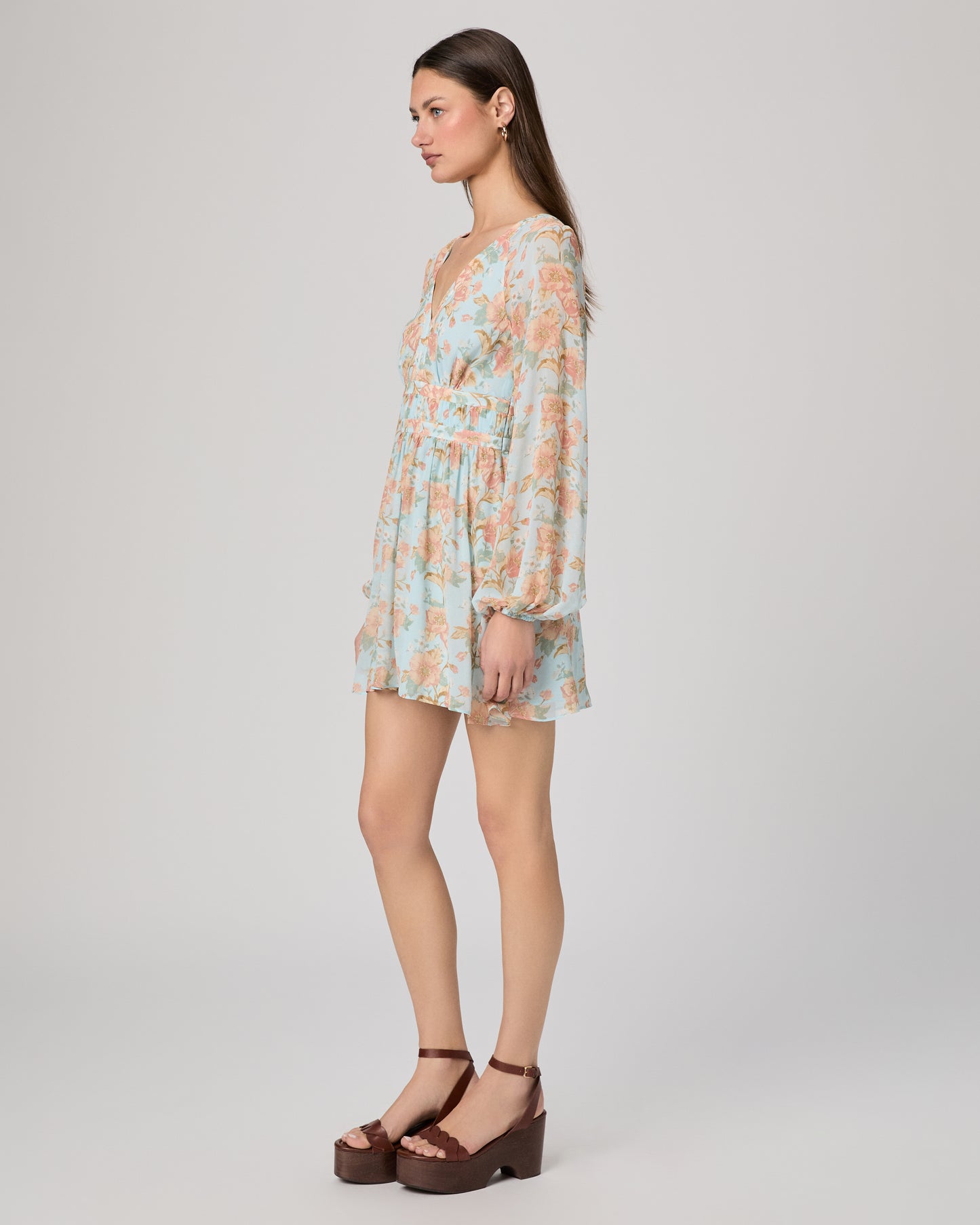 Woman wearing a floral dress on a plain background