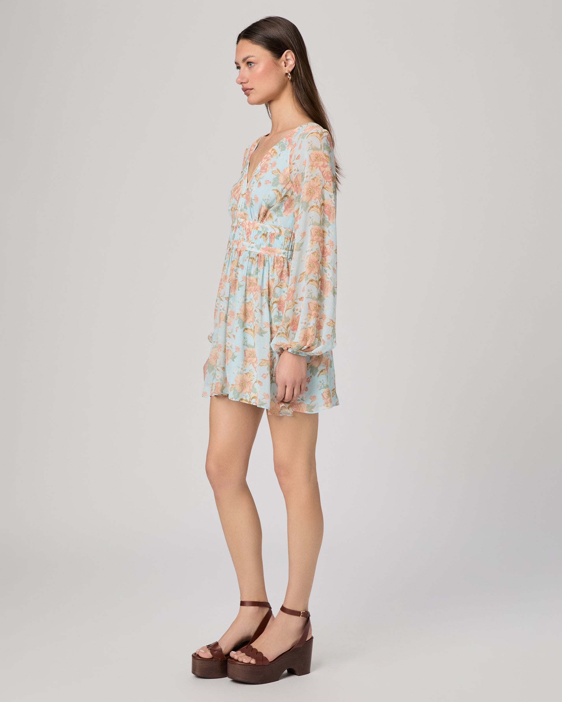 Woman wearing a floral dress on a plain background