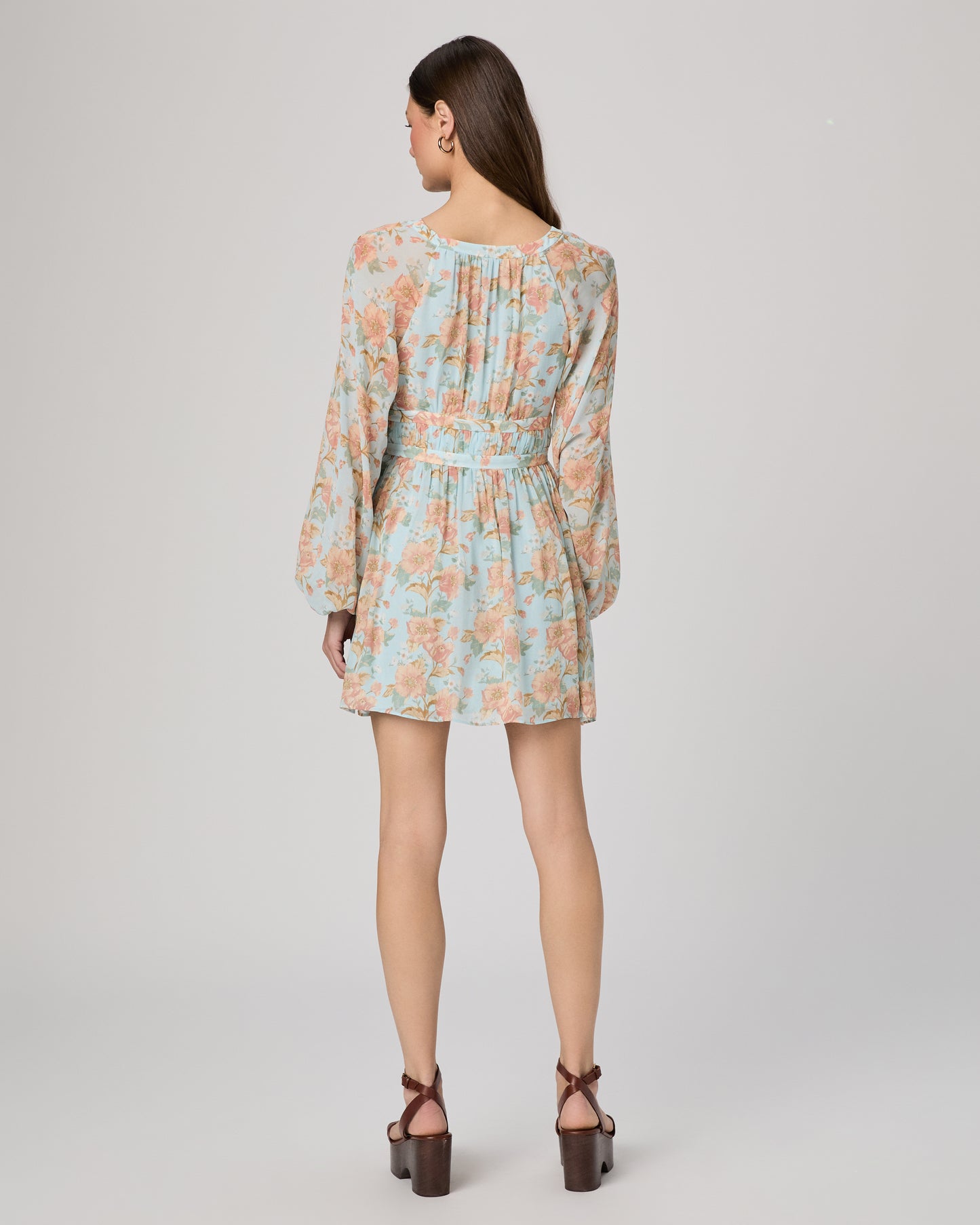 Woman wearing a floral dress on a plain background