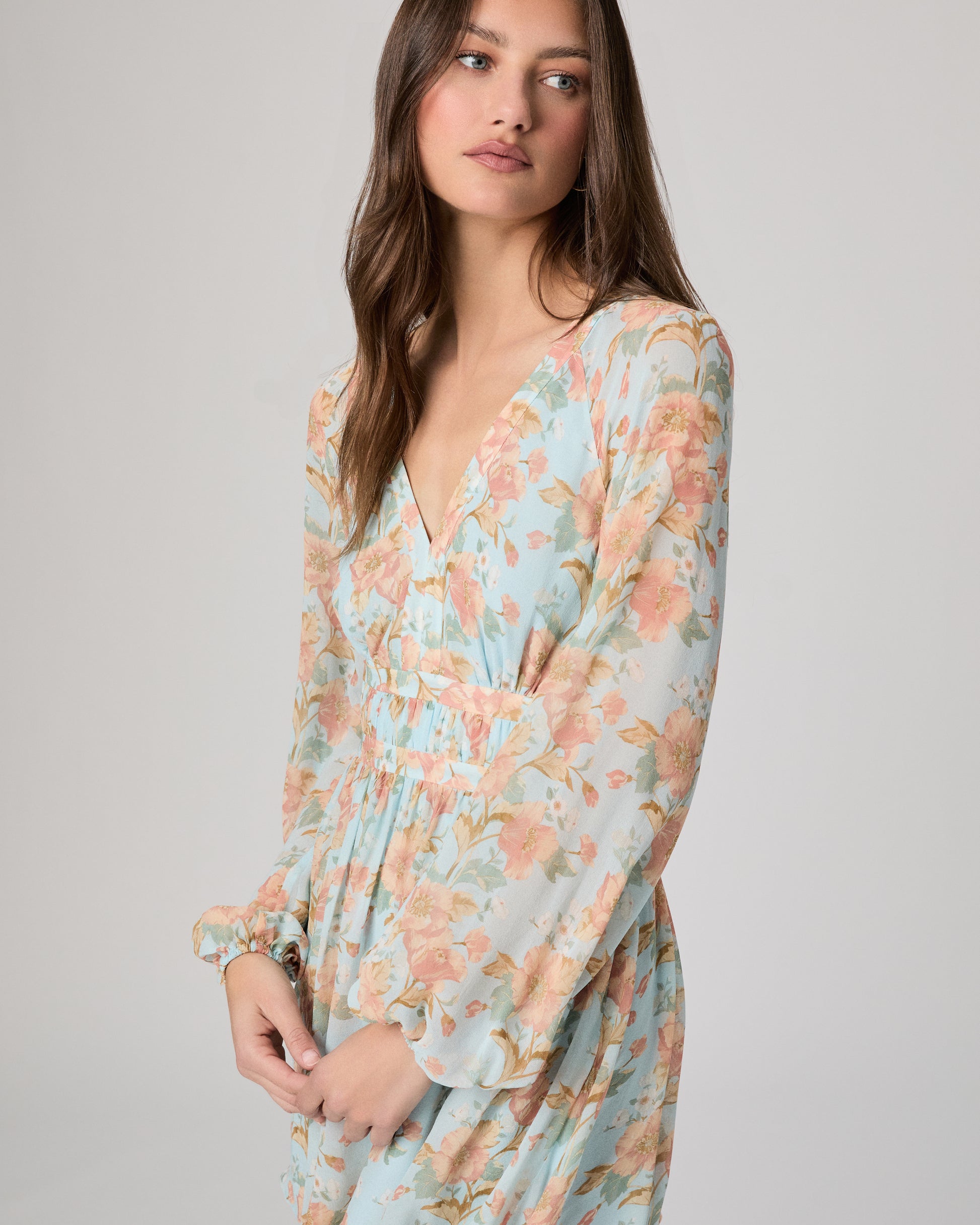 Woman wearing a floral dress on a plain background