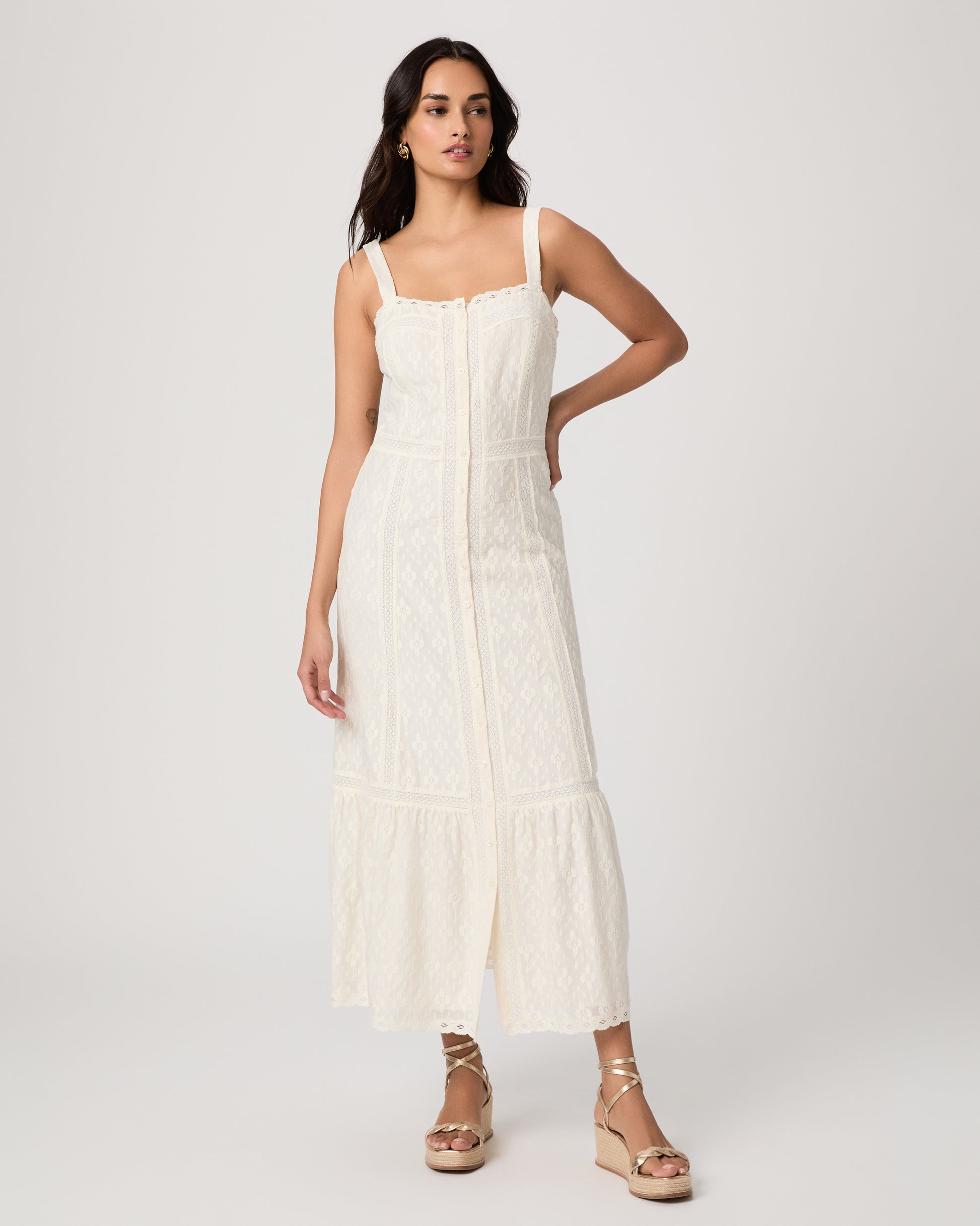 Woman wearing a white dress on a plain background