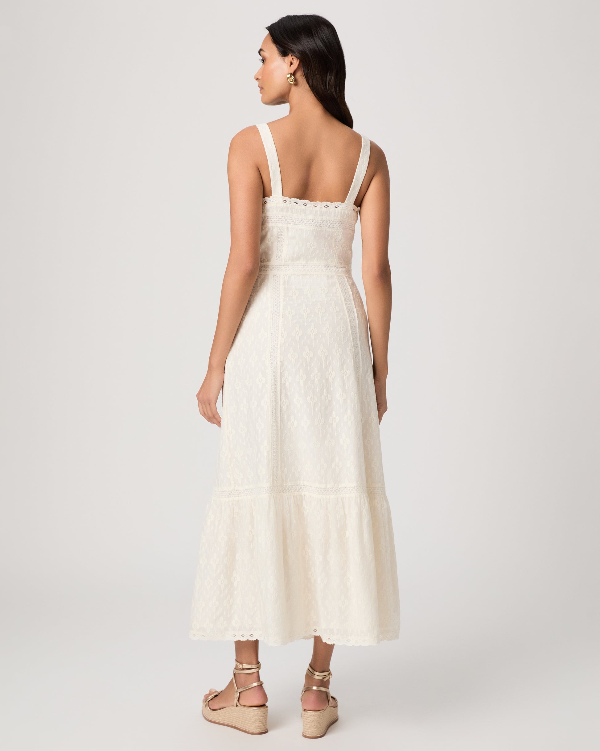 Woman wearing a white dress on a plain background