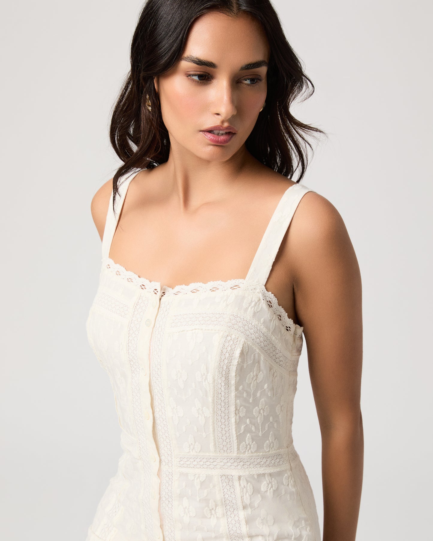 Woman wearing a white dress on a plain background