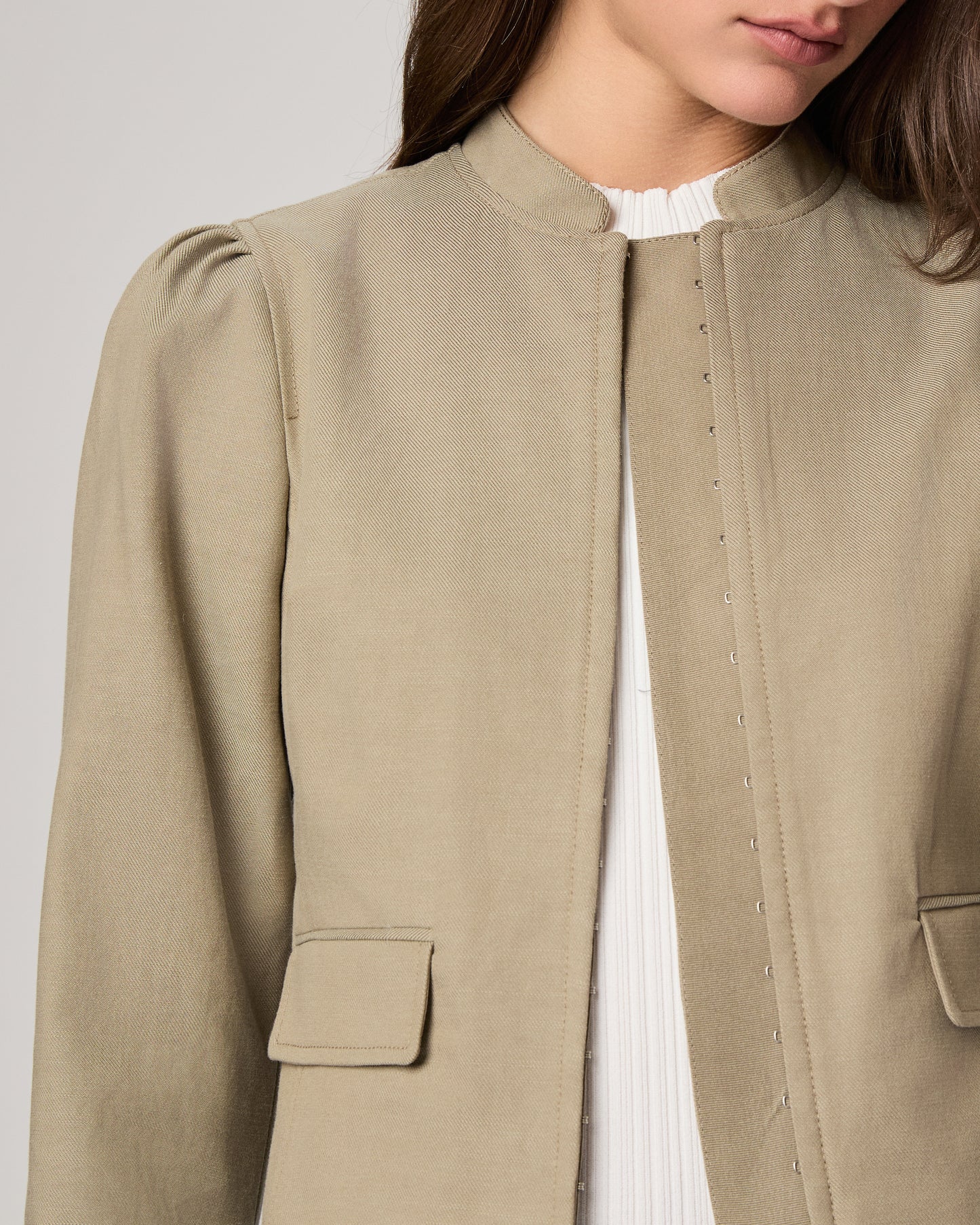 Woman wearing a light green jacket on a white background
