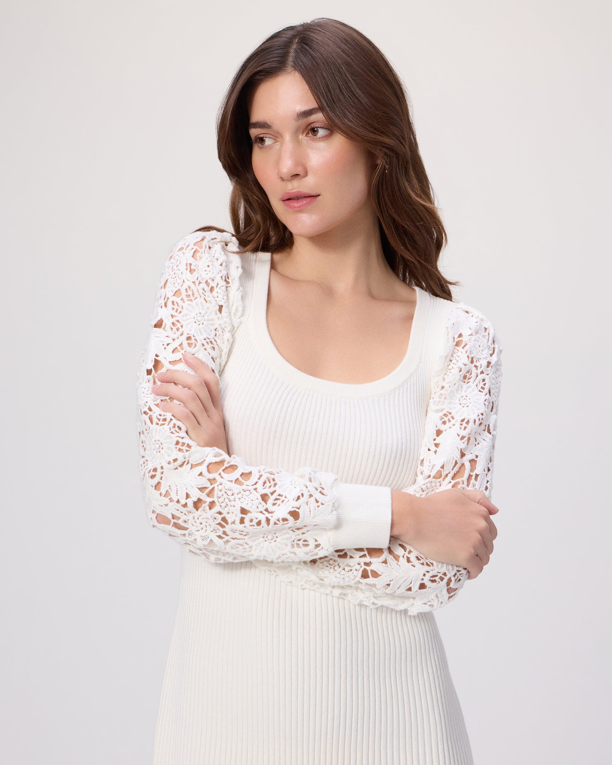 Woman wearing a white dress with a lace sleeves on a white background