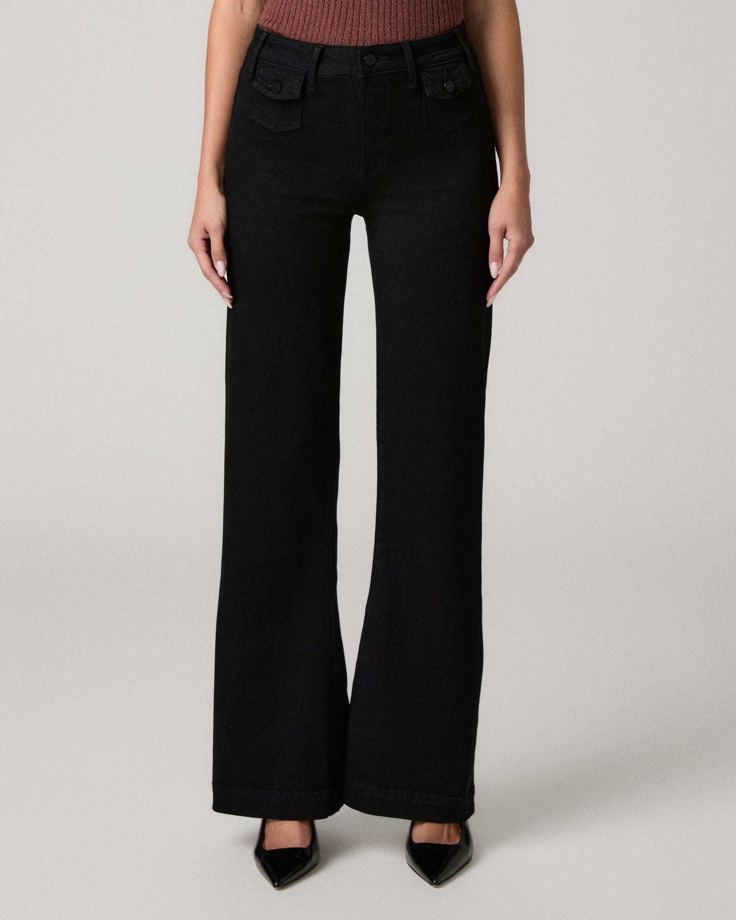 Women wearing burgundy shirt and black pants paired with black heels against a white background