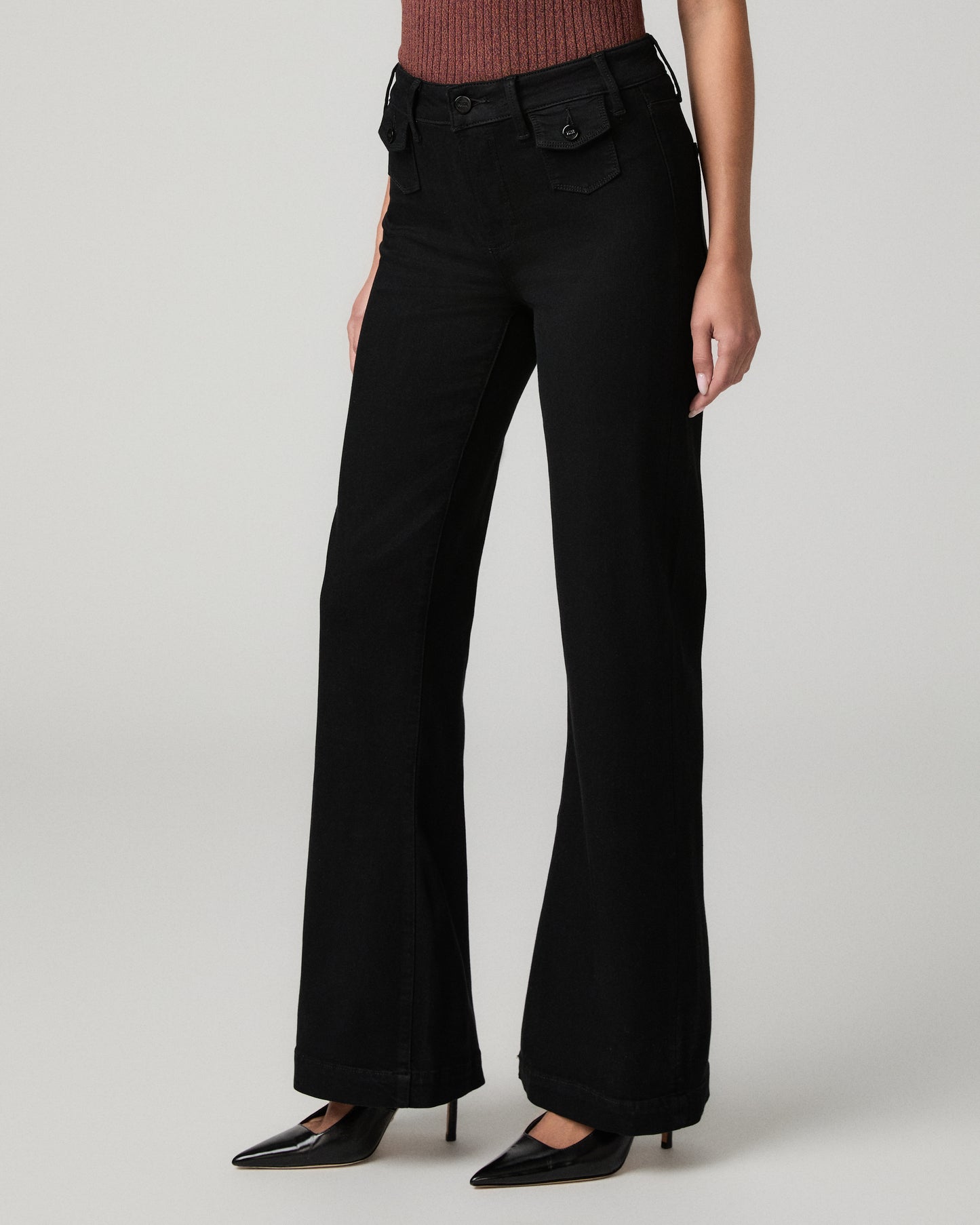 Women wearing burgundy shirt and black pants paired with black heels against a white background