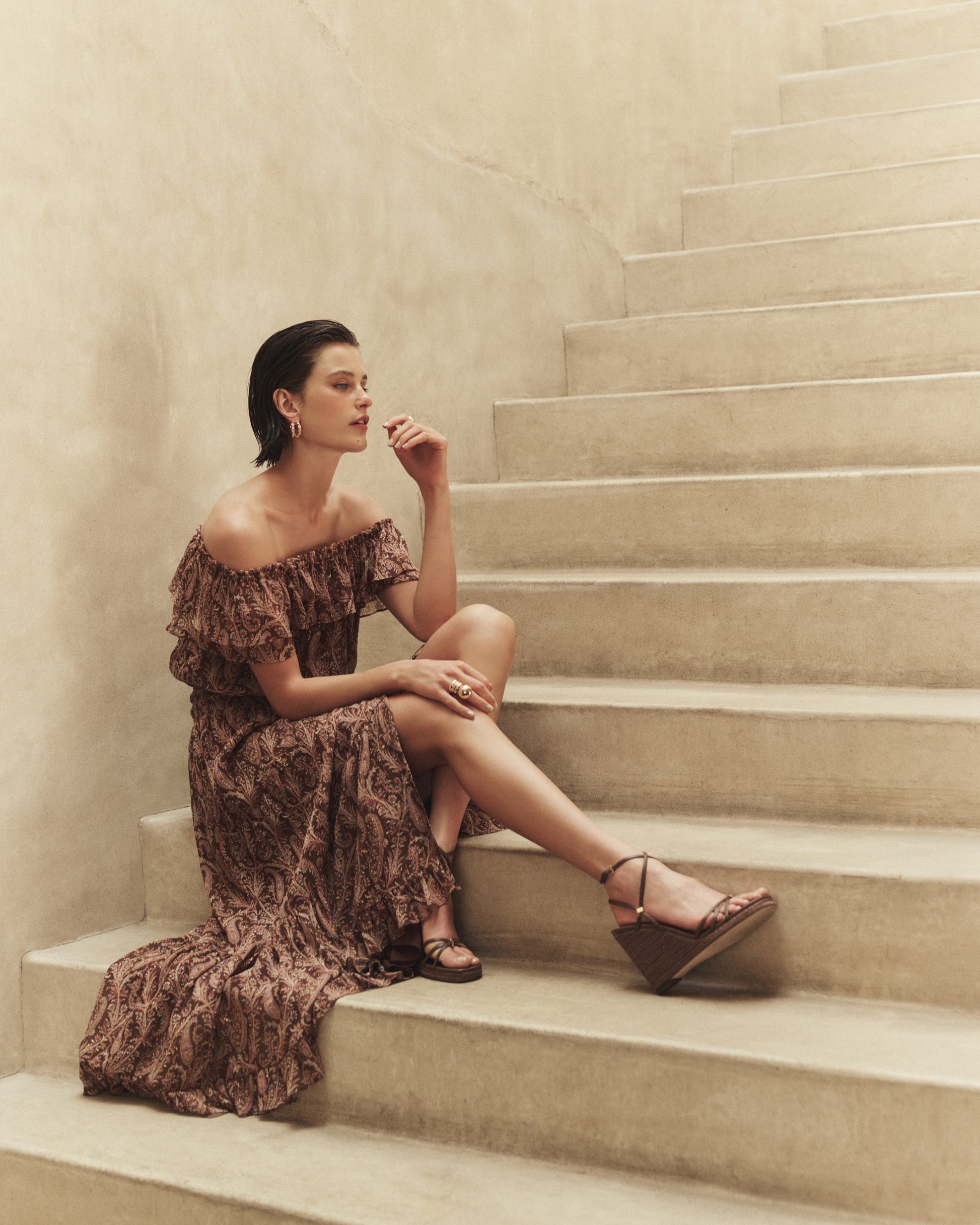 Woman in a patterned dress sitting on a staircase